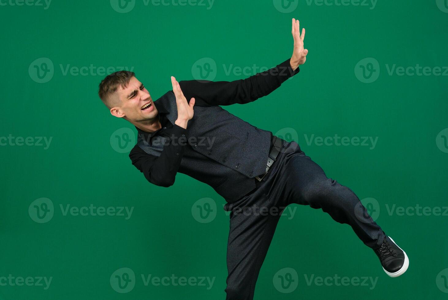 dissatisfied man pushes away with his hands emotions of a handsome man guy on a green background chromakey close-up dark hair young man photo
