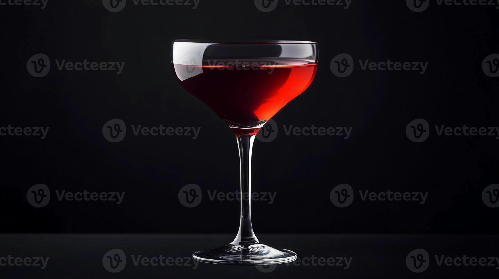 A glass of red wine is sitting on a table. The wine is almost gone, and the glass is almost empty photo