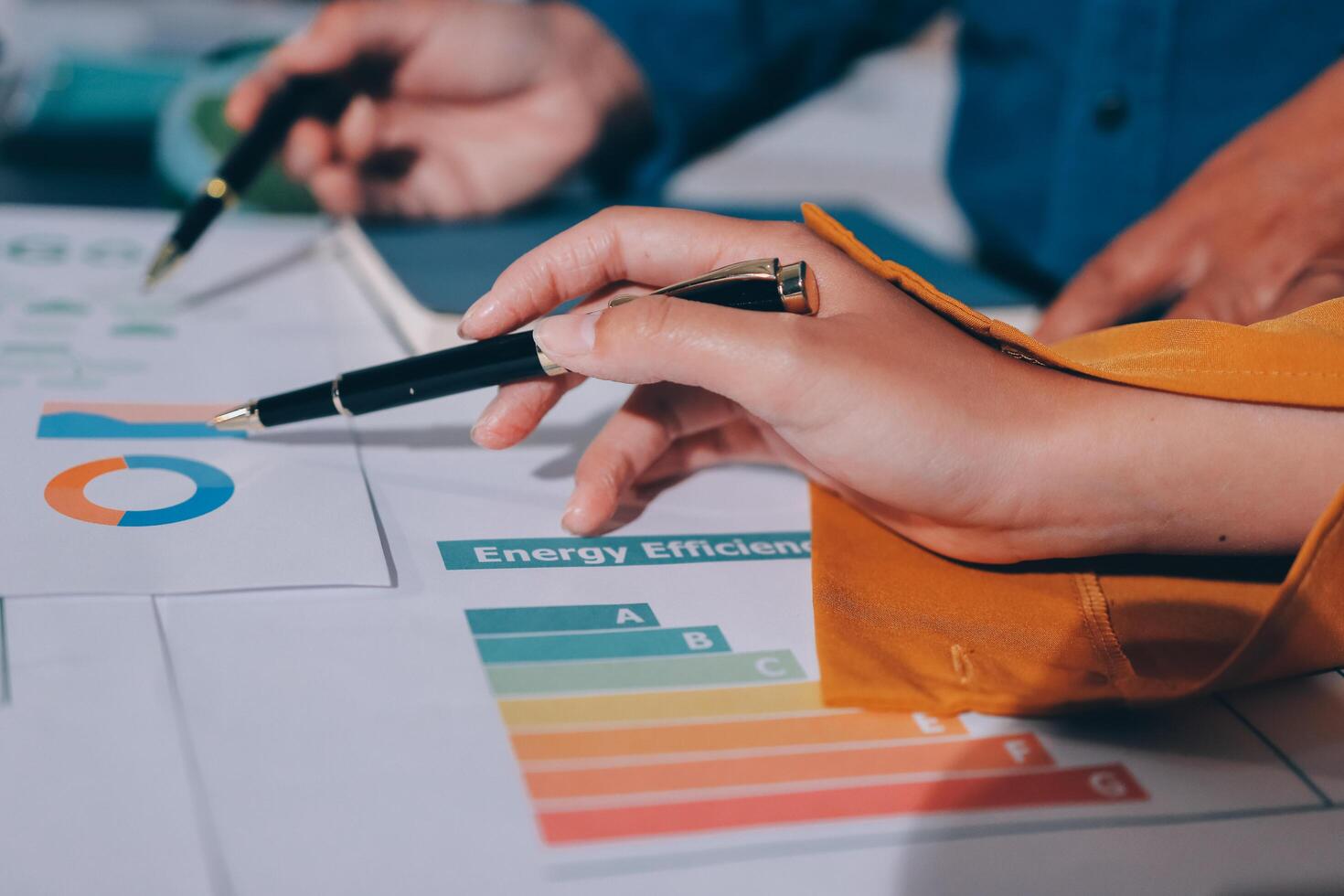 A person is holding a pen and pointing to a chart photo