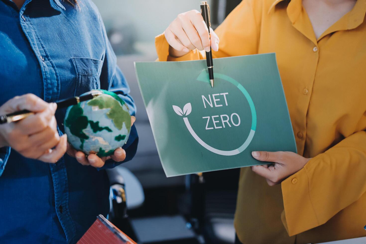 Two people holding a net zero sign photo