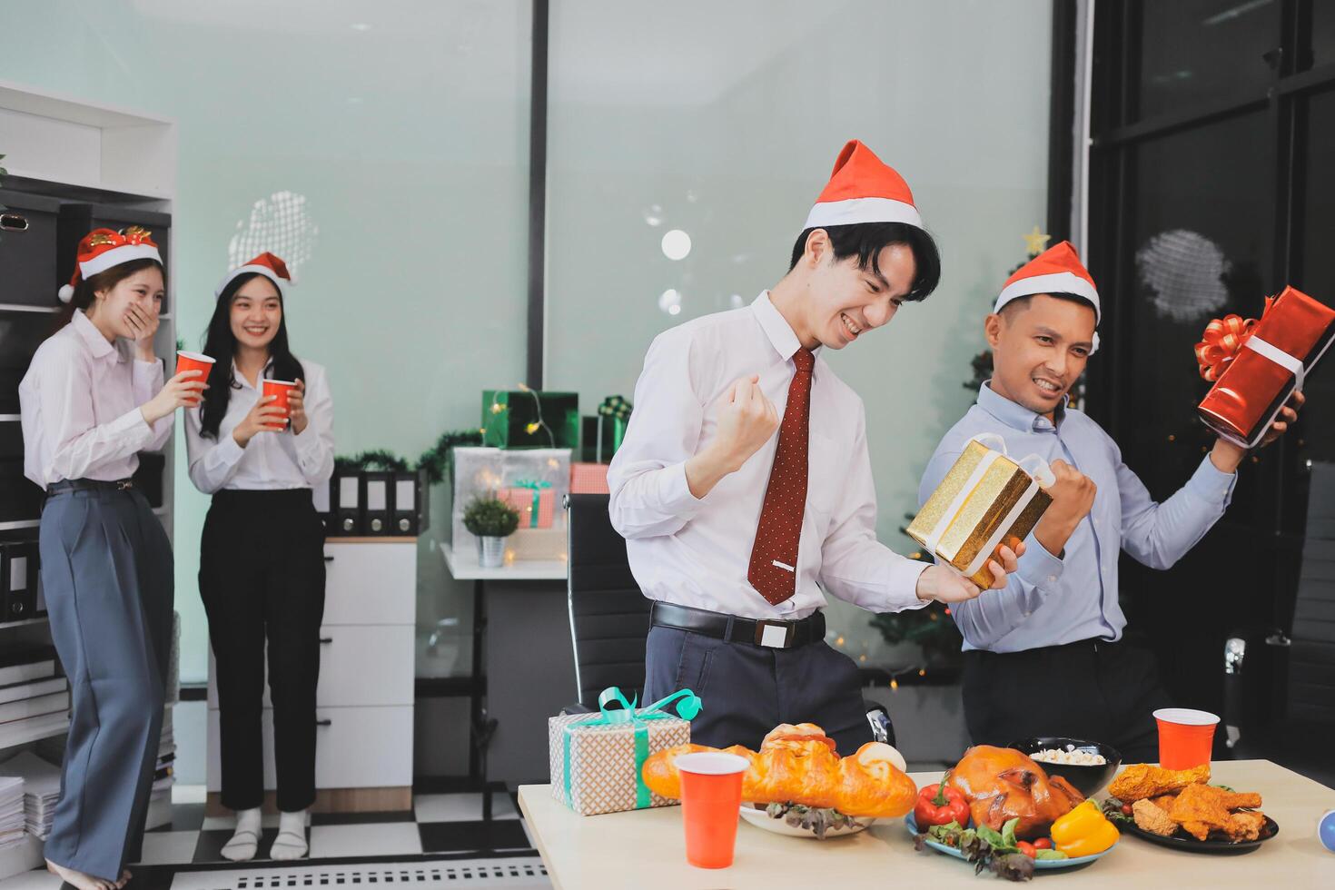A group of people in christmas hats and hats are holding presents photo
