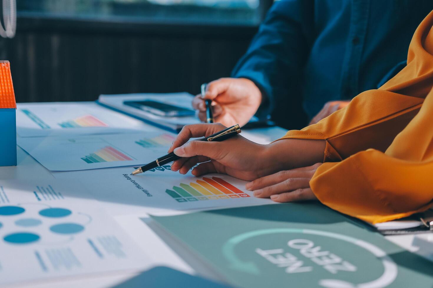 Business people working on a project with graphs and papers photo