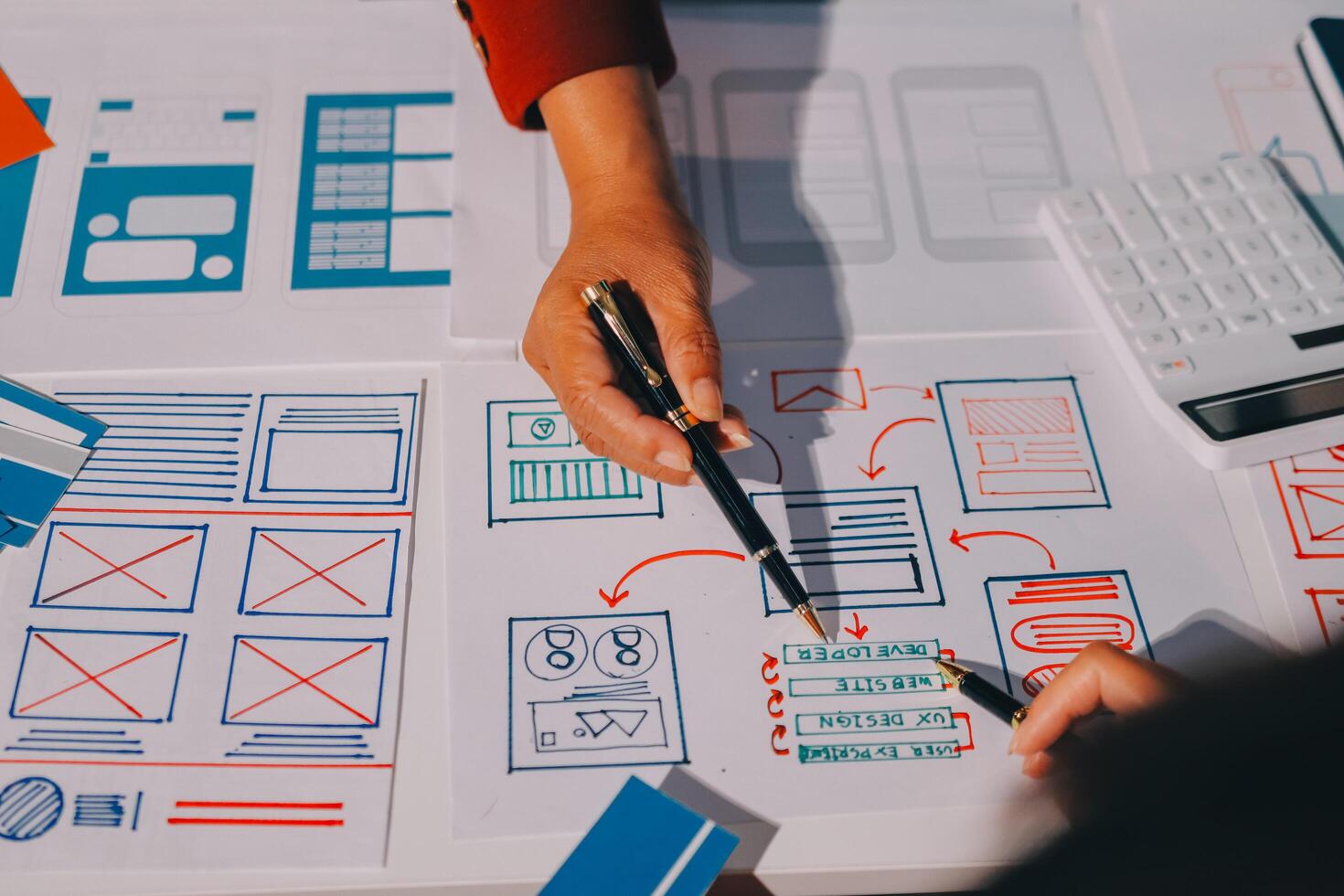 A person is working on a design with a pen and calculator photo