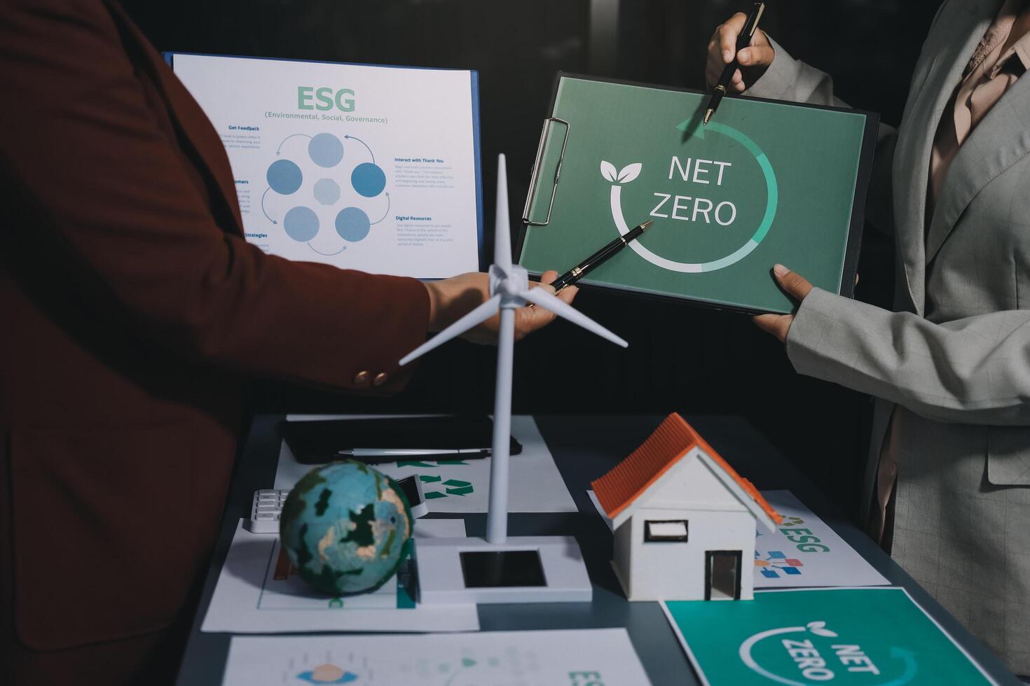 Two people holding up a sign that says net zero photo