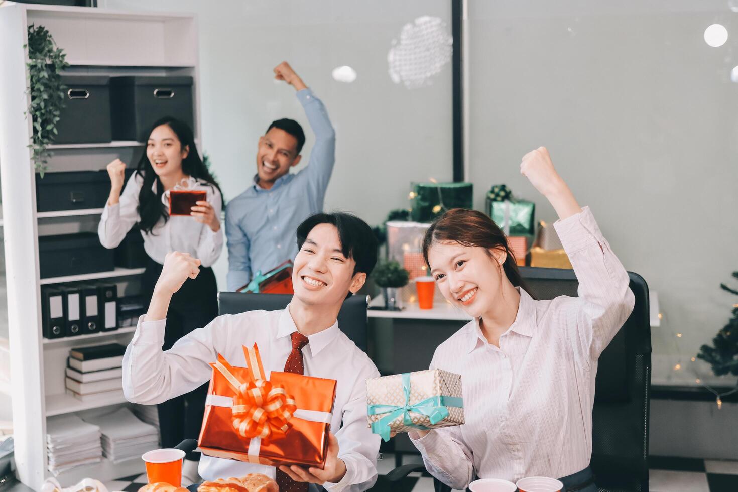Happy asian business people celebrating christmas in office photo