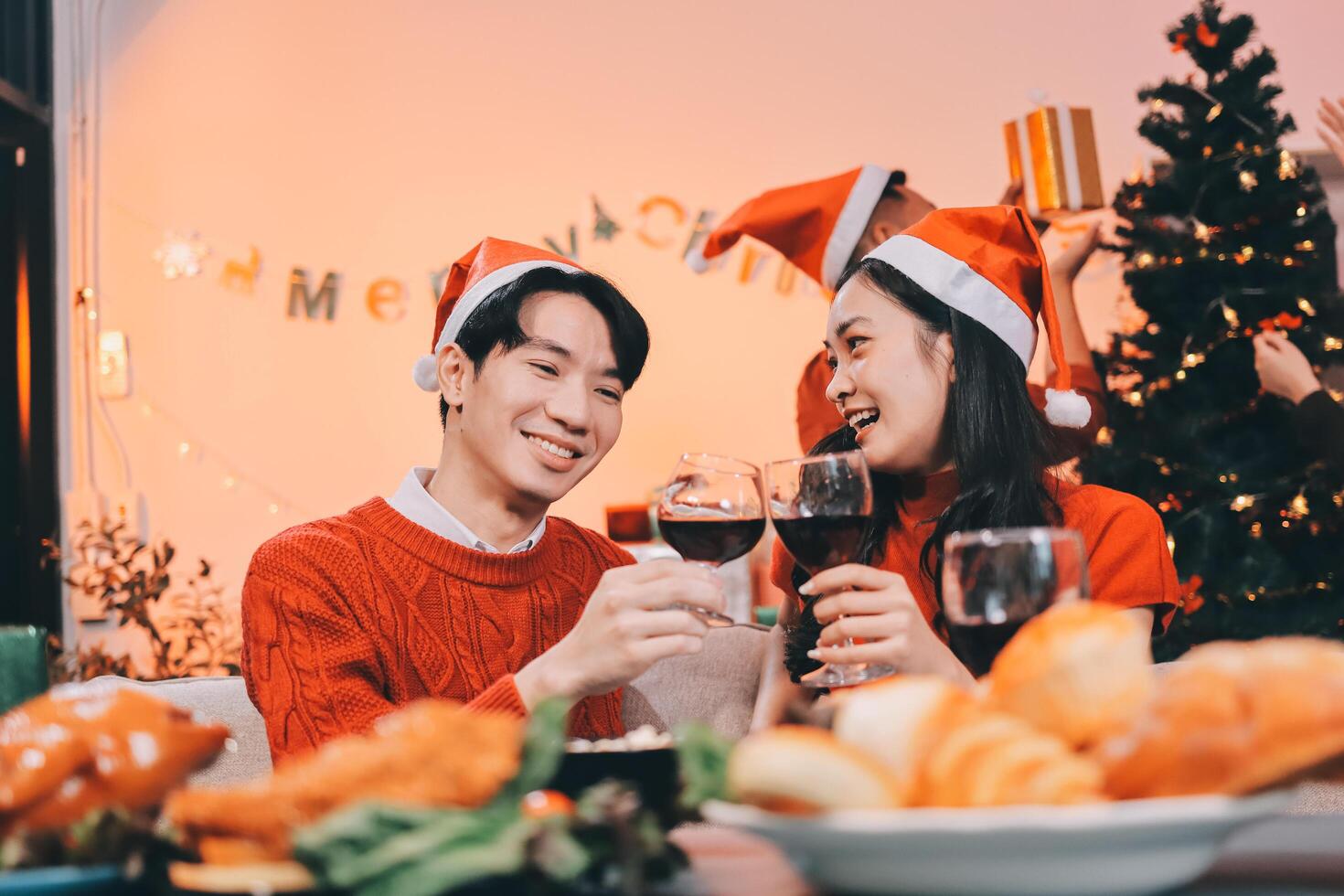 A couple in santa hats toasting wine photo