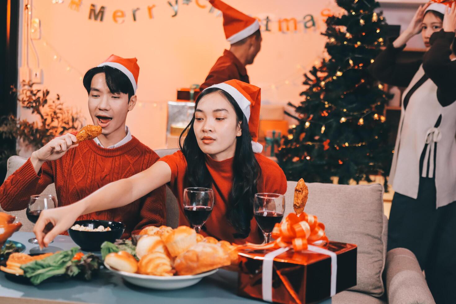 A couple in christmas hats eating food photo