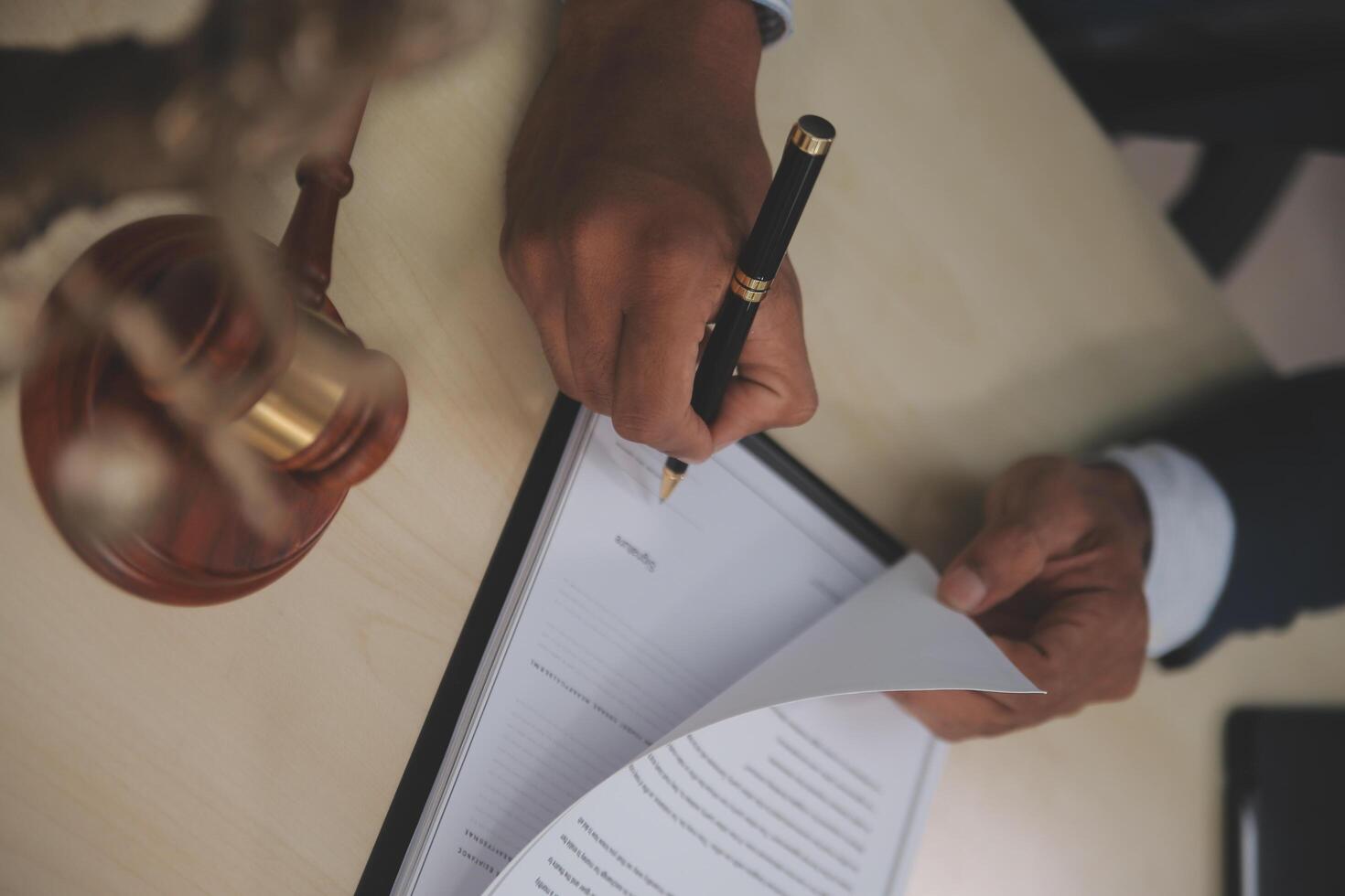 A man signing a contract with a pen and paper photo