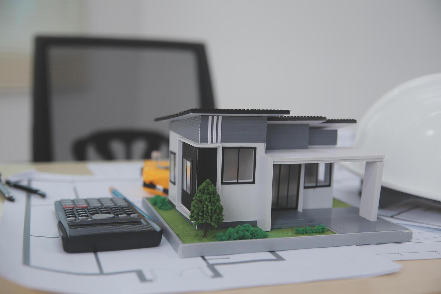 A model of a house sits on top of a desk photo
