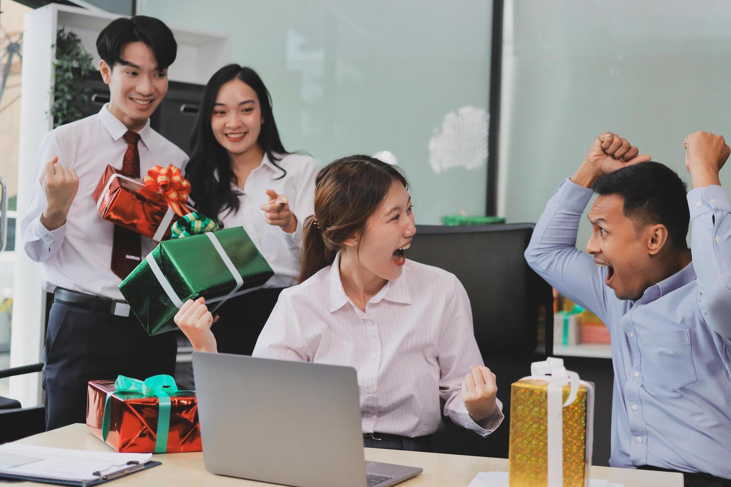 Happy asian business people celebrating christmas with gifts photo