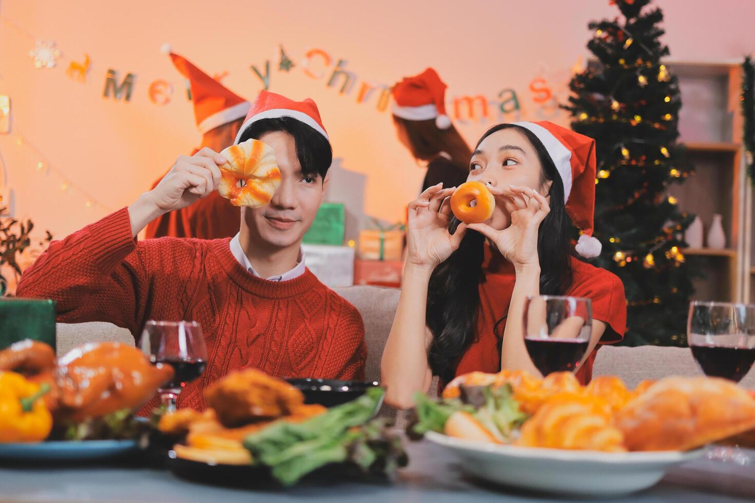 A couple in santa hats eating food photo