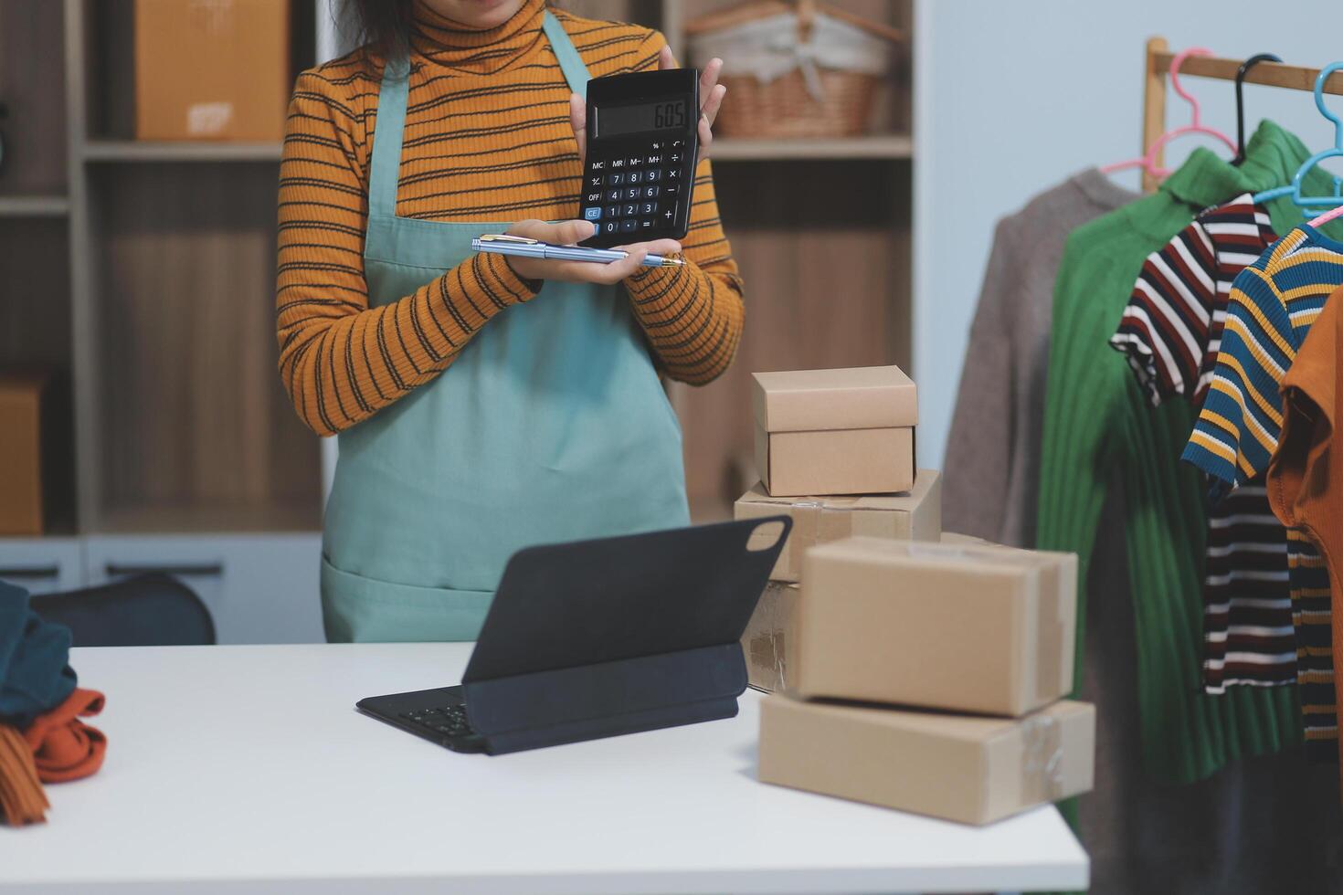 A woman is holding a calculator and looking at her phone photo