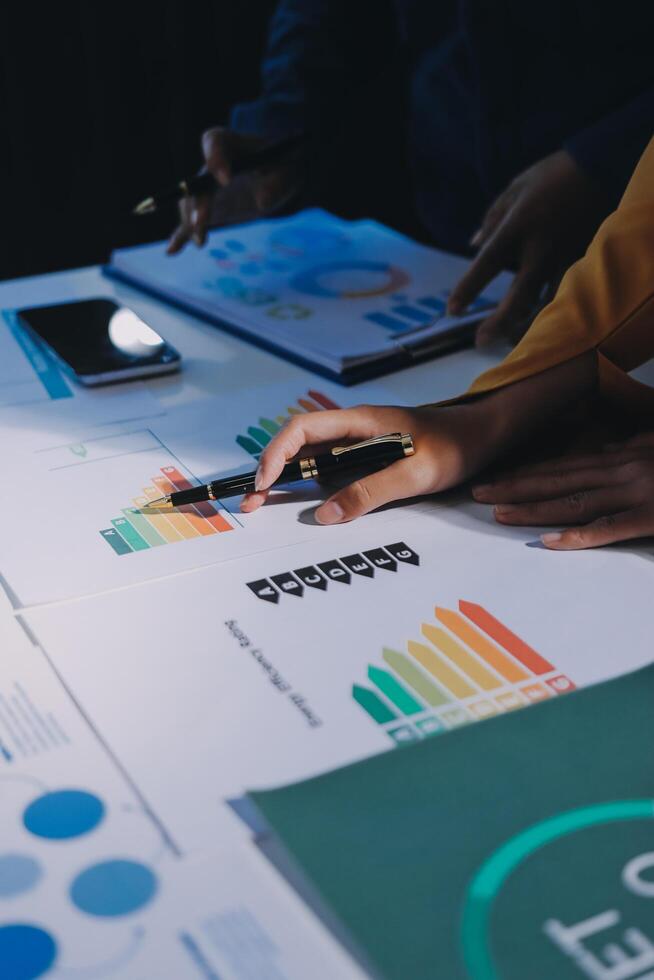 Business people working on a table with graphs and charts photo