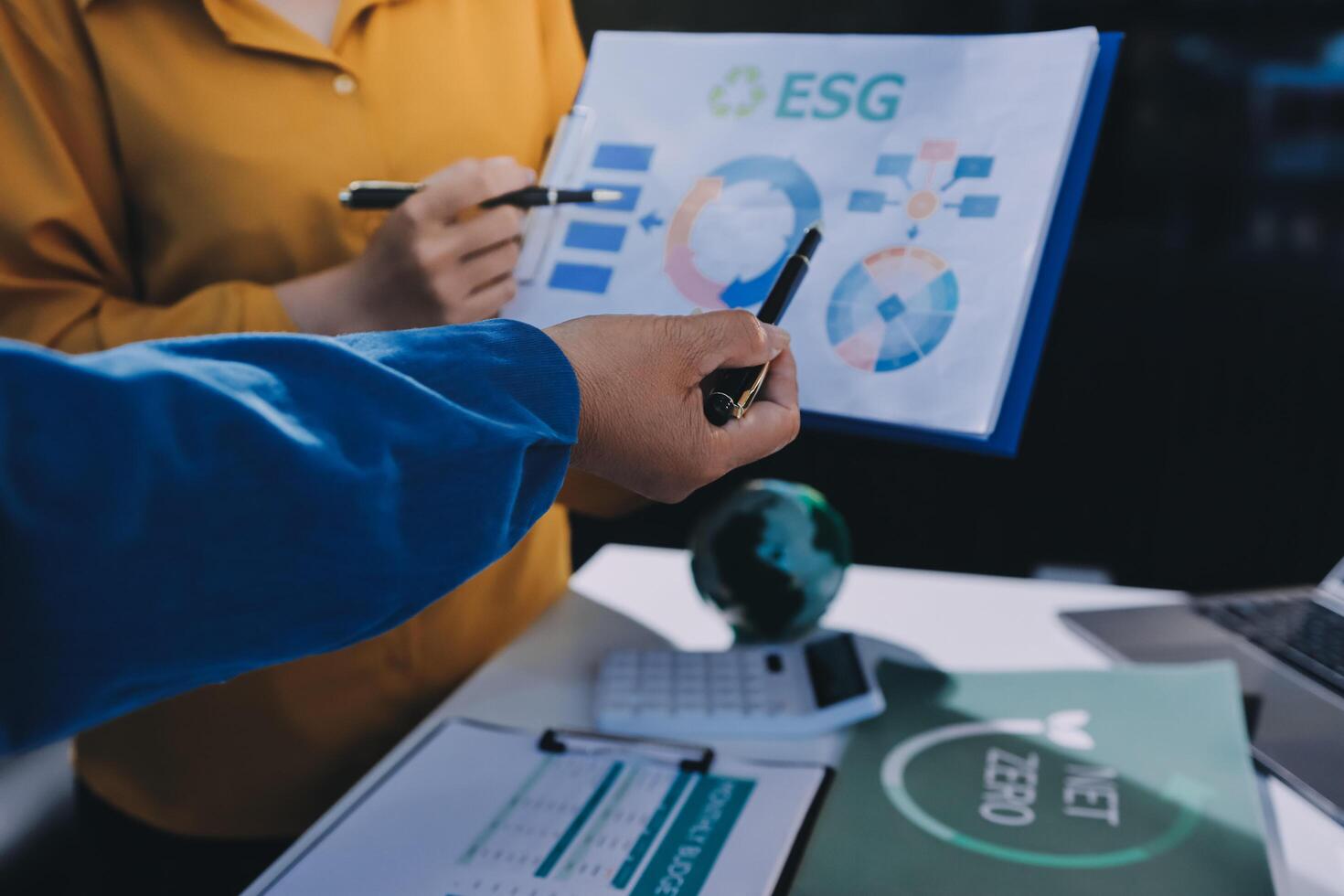 Business people working with a laptop and a paper with graphs photo