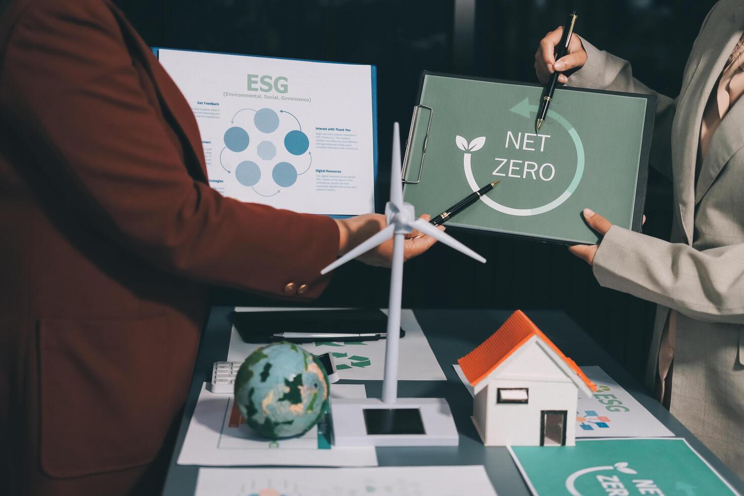Two people holding up a sign that says net zero photo