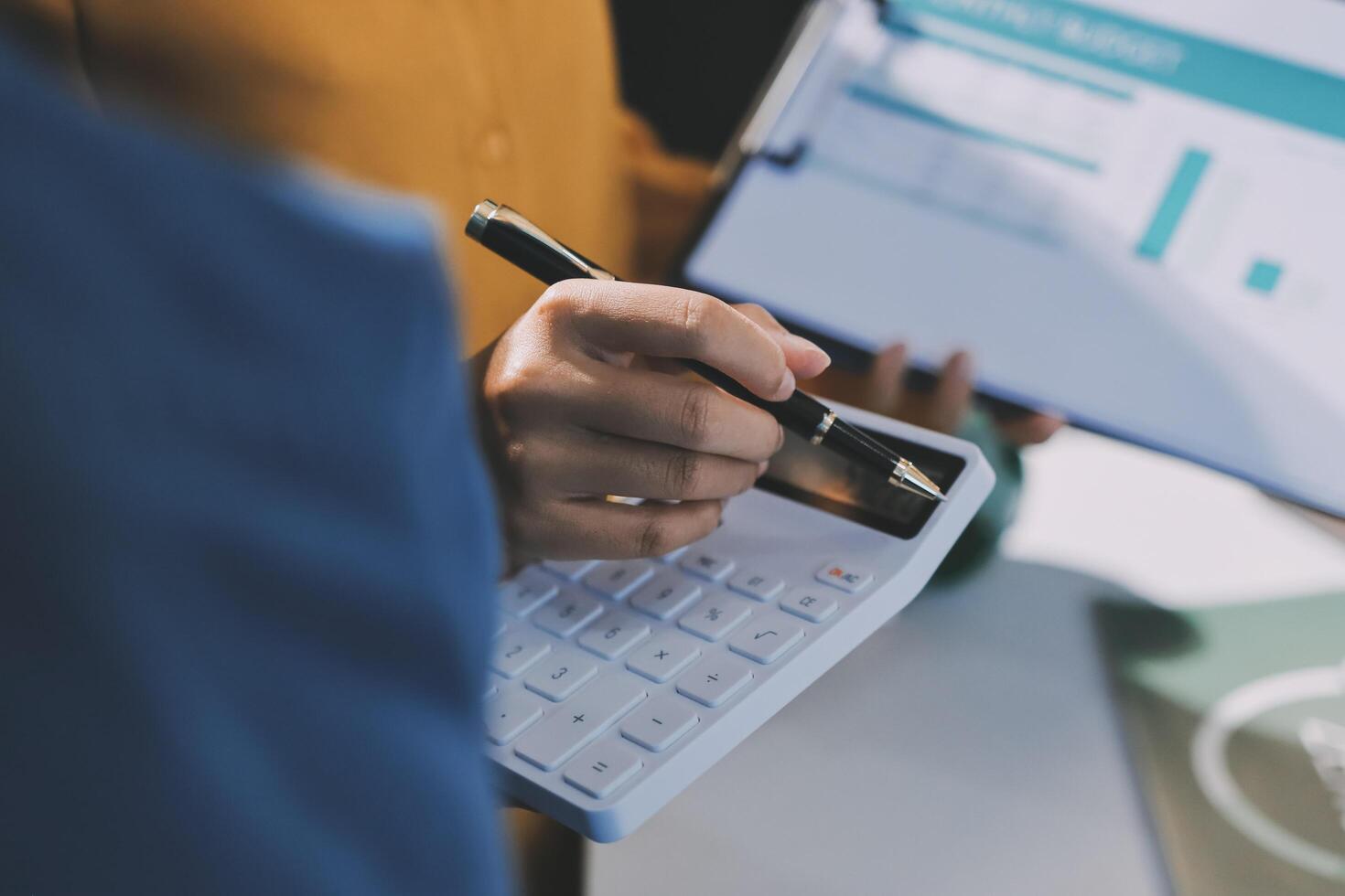 Businesswoman using calculator to calculate the cost of a project photo