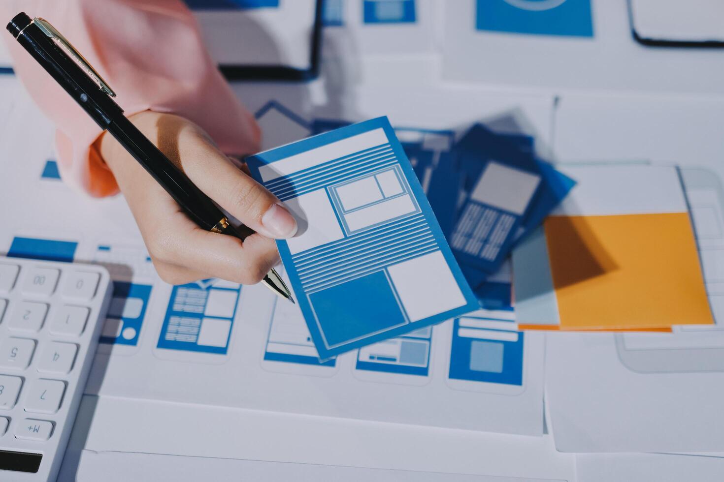 A person is using a pen to write on a blue and white paper photo