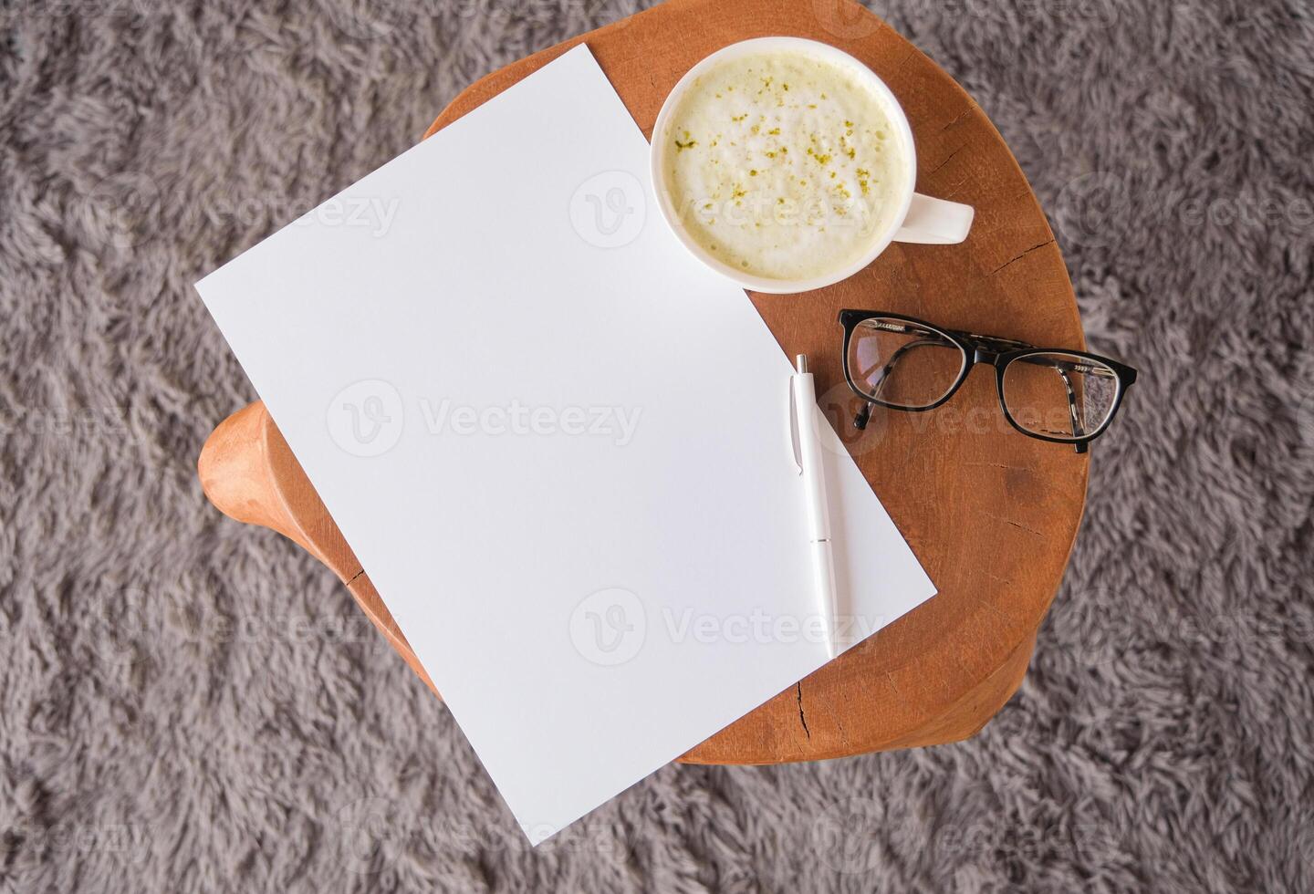 top view of blank paper sheet mockup on coffee table with green matcha latte photo
