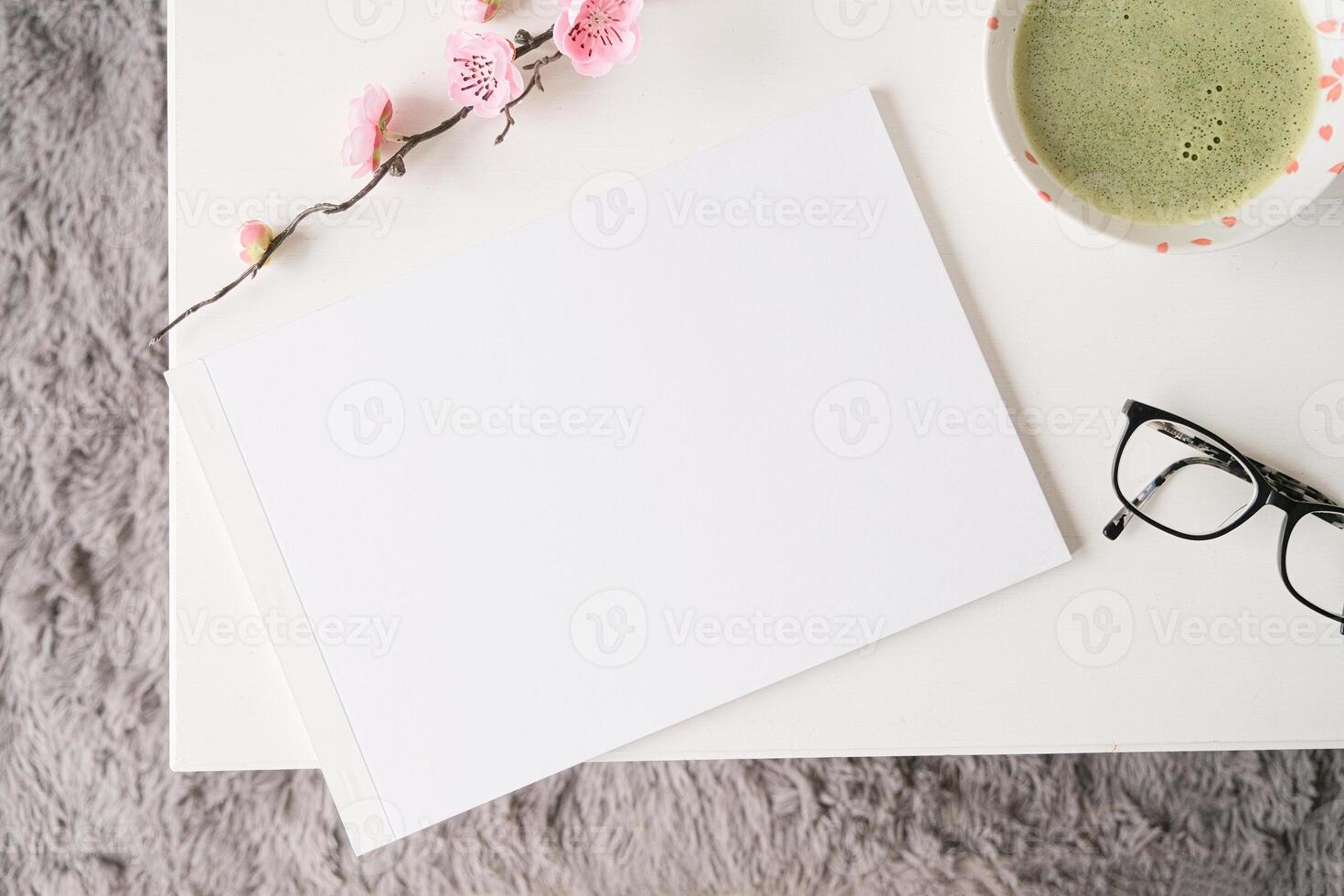 blank A4 magazine mockup on white coffee table with green matcha tea photo
