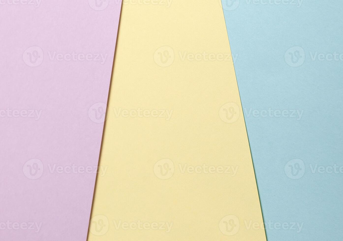 Pastel abstract geometric paper background featuring lavender, yellow, and blue hues arranged in a photo
