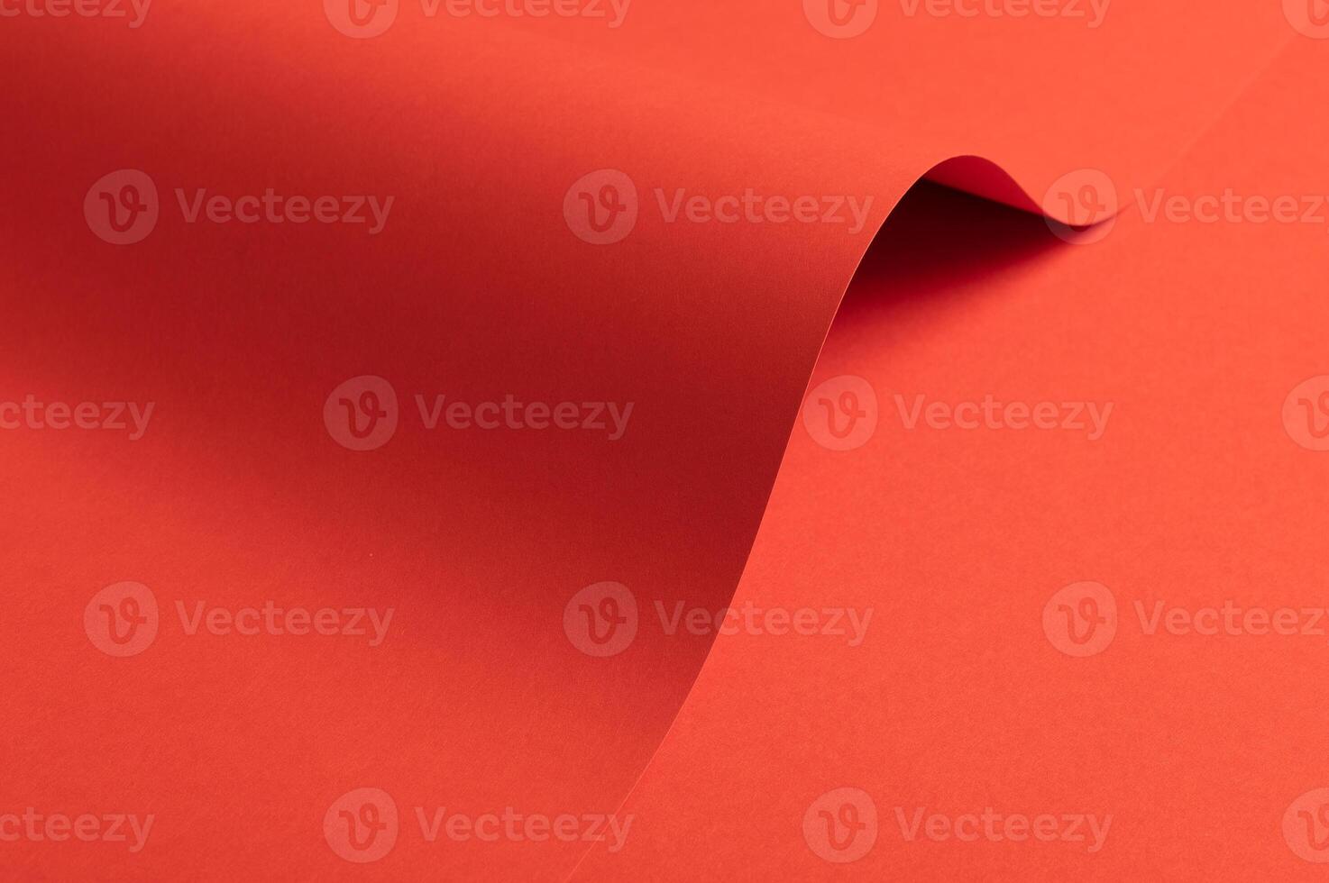 Fiesta red and orange paper background with a matte finish and smooth, curved folds. Vibrant, bold photo