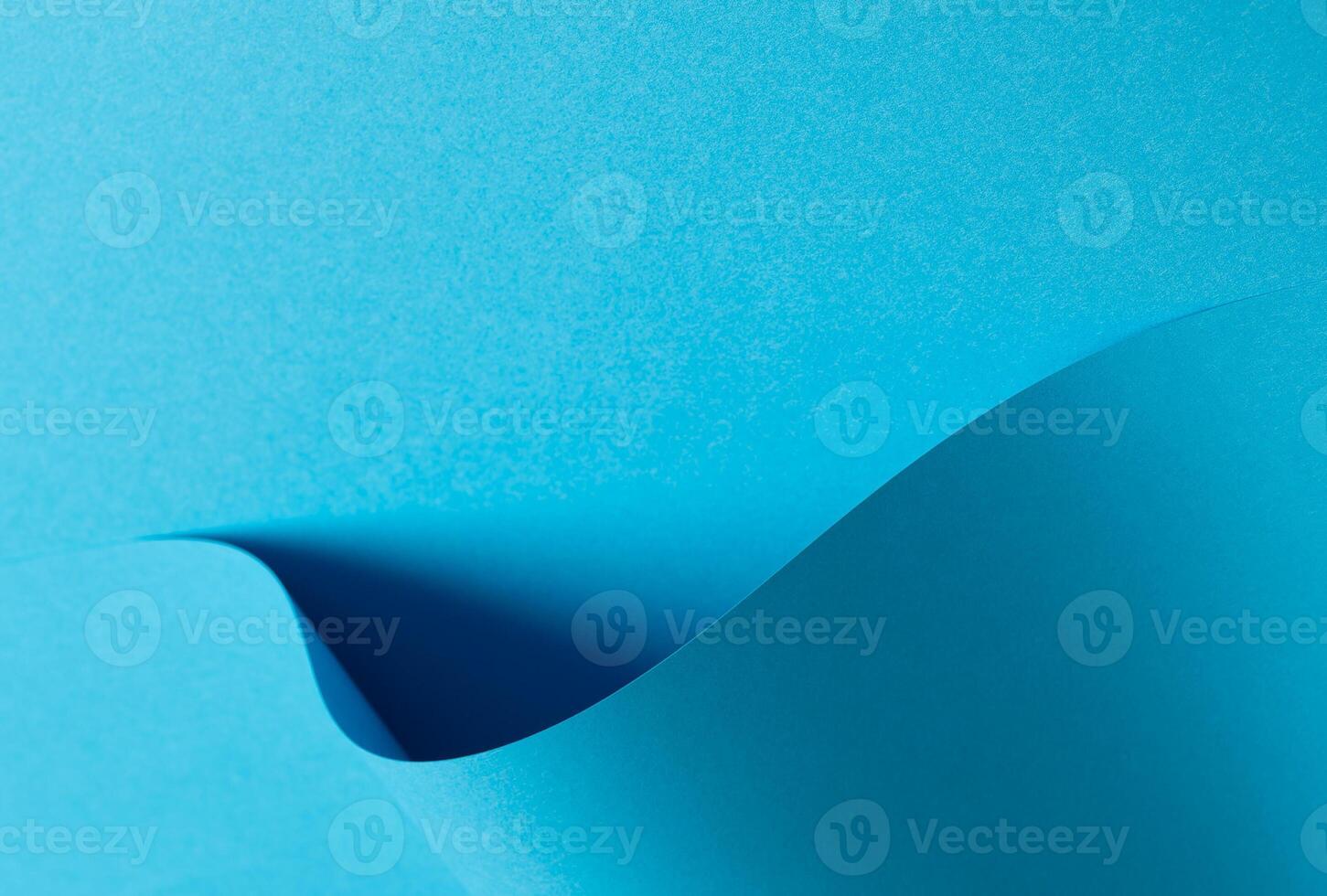 Blue paper background with a smooth matte finish and layered geometric accents. Soft shadows and a photo