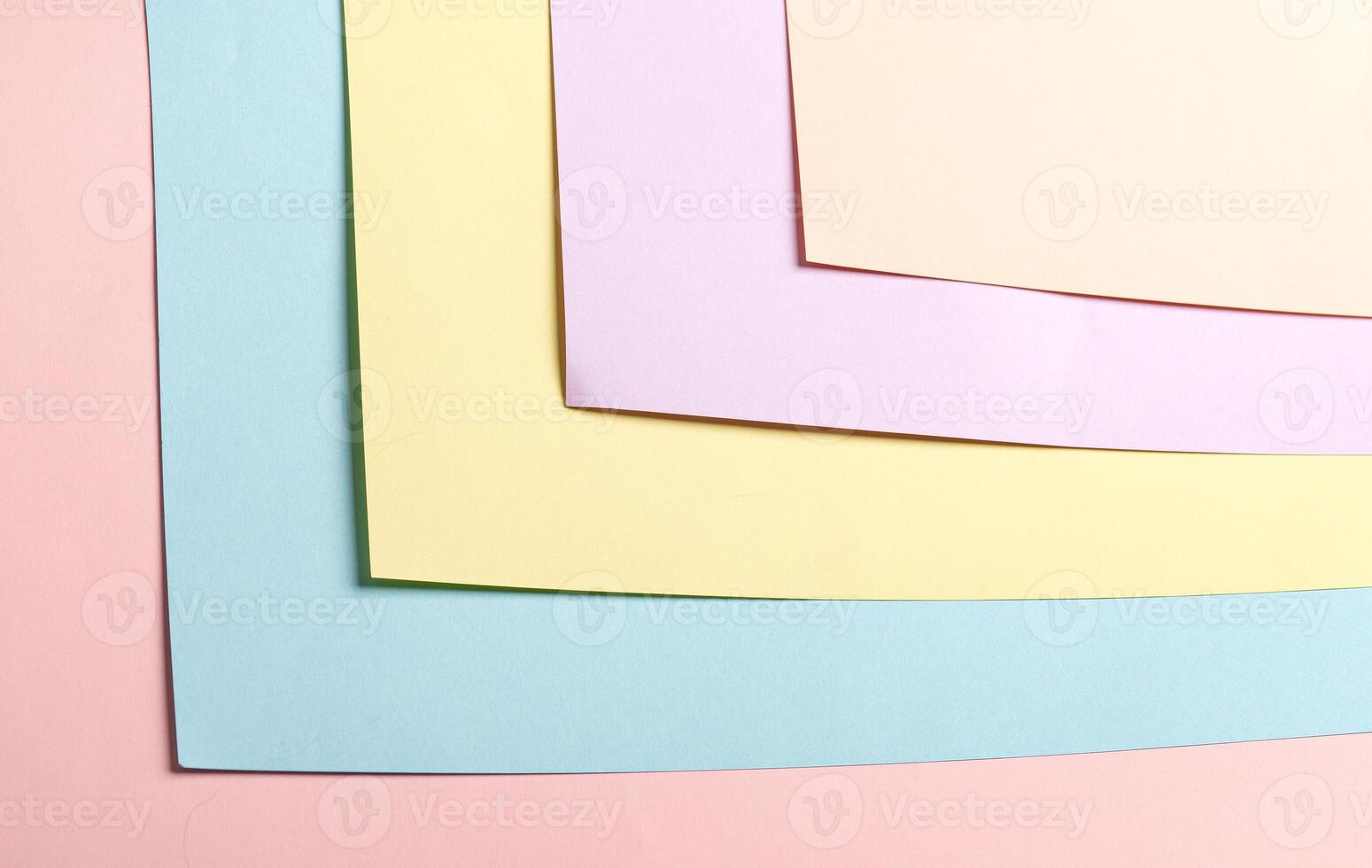 Pastel abstract geometric paper background featuring pink, blue, yellow, lavender, and peach hues in photo