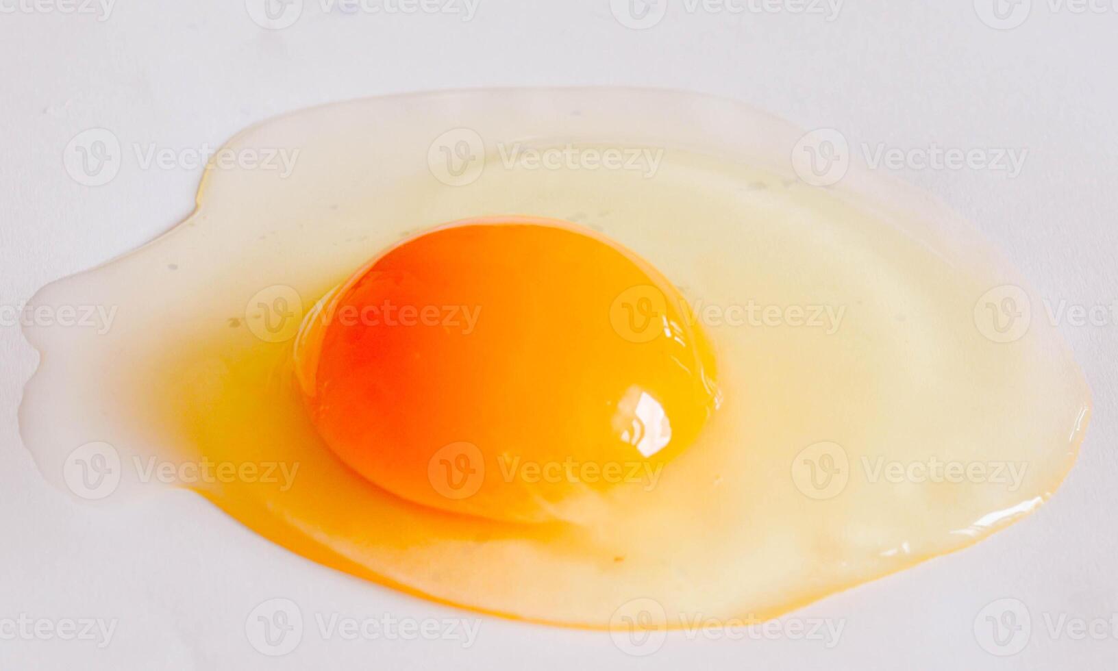 Cracked Egg with Runny Yolk on White Background Macro Food Photography photo