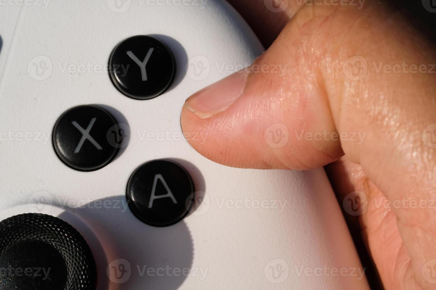 Pressing buttons on a white gamepad. The game controller buttons are set soft and ergonomic. Finger mechanics and gameplay. Hobbies and leisures. Macrophotography Theme photo
