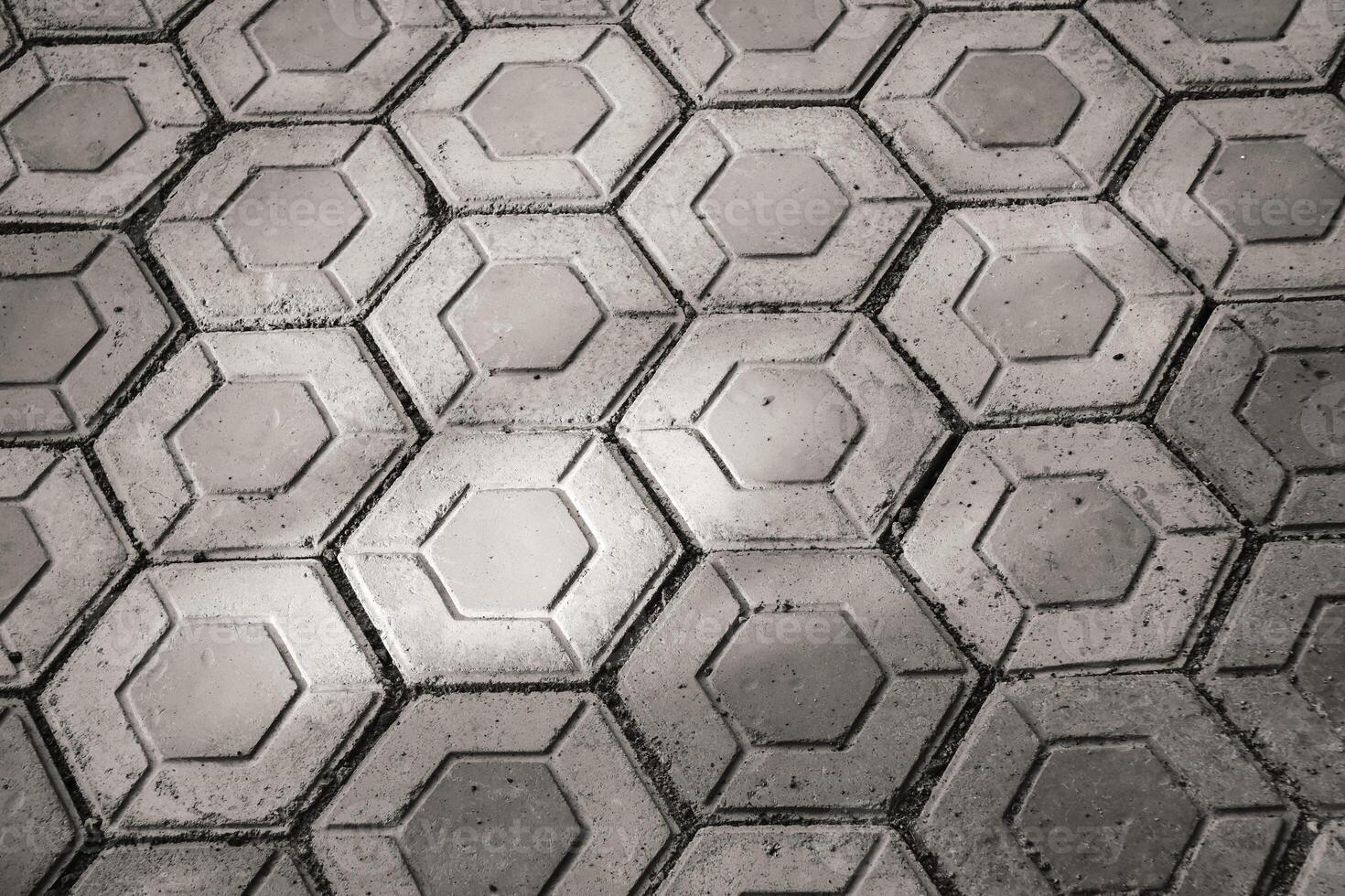 Monochrome hexagonal paving block exposed to morning sunlight. Black and white paving block neatly arranged. Hexagon pattern pavement outdoor texture. Wallpaper Backgrounds photo