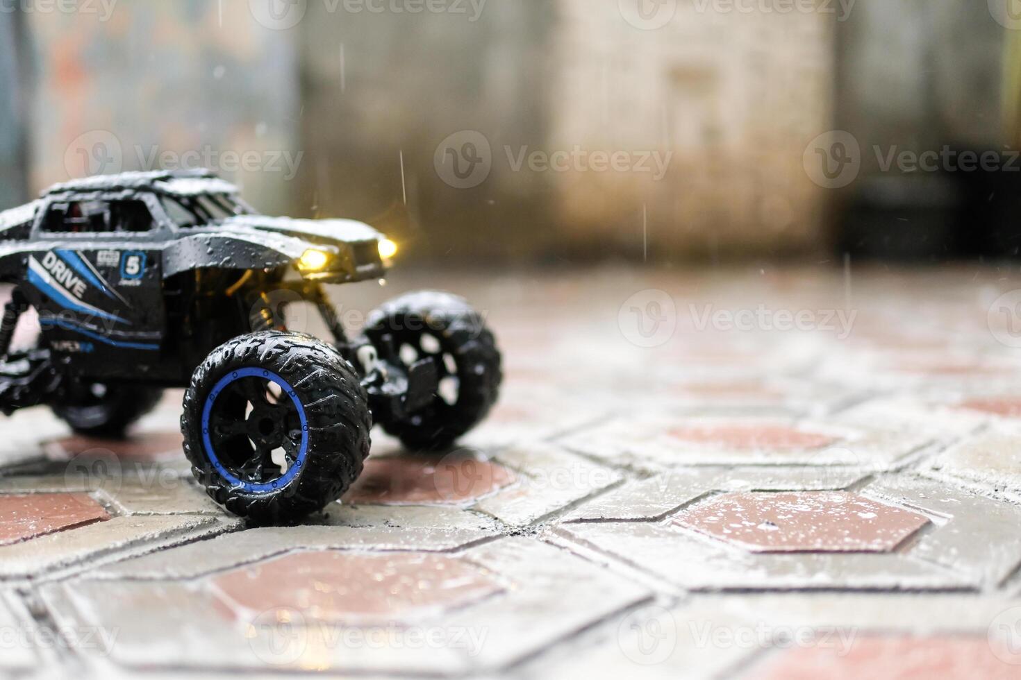 Toy car during outdoor with lights on. Remote Control Car being played in the yard during rain. Hobbies and Leisures. Graphic Resources. Toy Photography Concepts photo