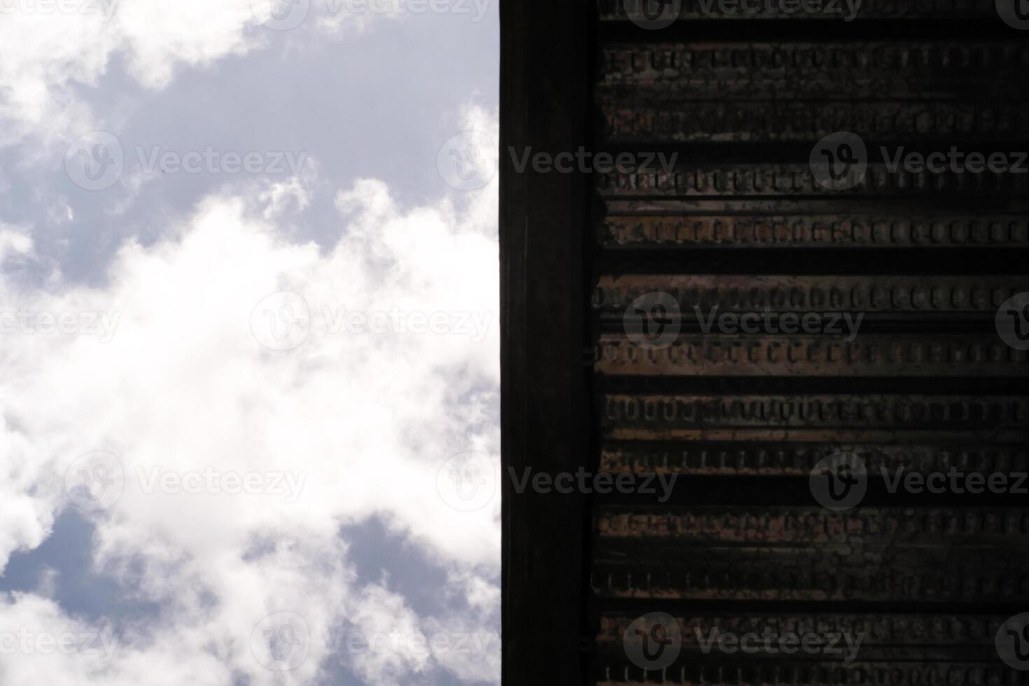 Backgrounds Split in half. One side shows a cloudy sky and the other side is covered by a roof. Low angle shot. Wallpaper Backgrounds. Negative Space. photo