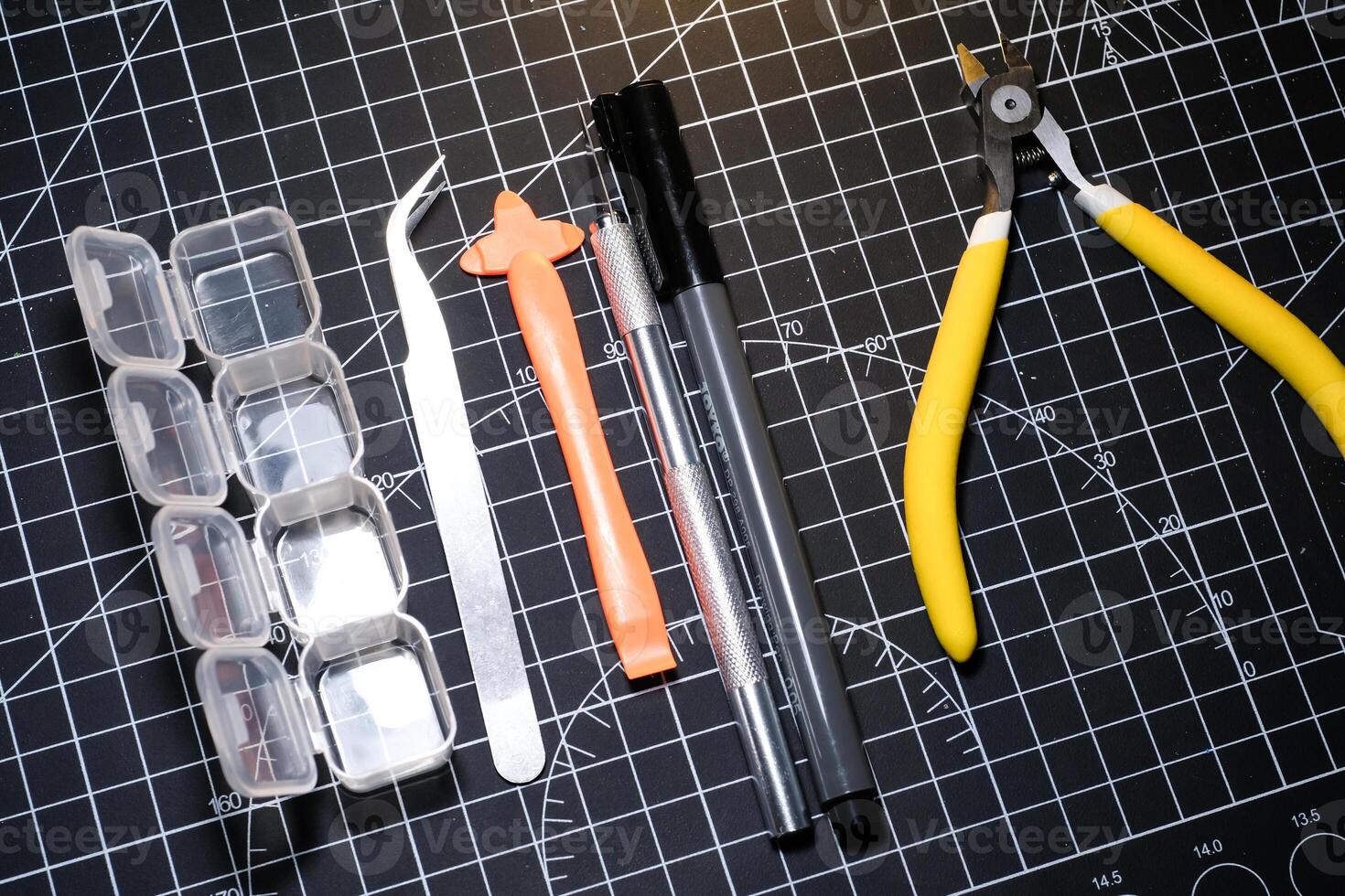 Set of hobby tools for building plastic model kits. Consisting of Nipper, Ink pen, cutting blade, plastic separator, tweezer, and transparent plastic container. Tools and equipments photo