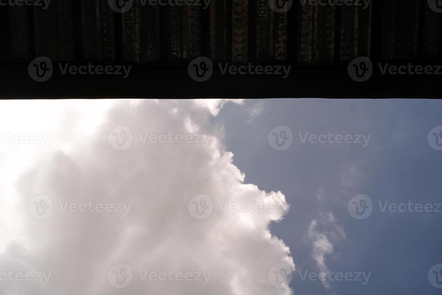 Backgrounds The blue sky is partially covered by the roof. One side shows a cloudy sky and the other side is covered by a roof. Low angle shot. Wallpapers Backgrounds. Negative Space. photo
