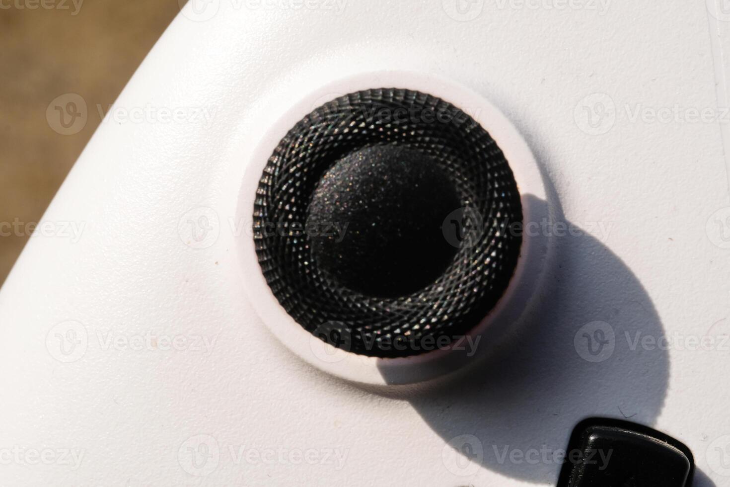 White gamepad with black joystick with rubber. The game controller buttons are set soft and ergonomic. Finger mechanics and gameplay. Hobbies and leisures. Macrophotography Theme photo