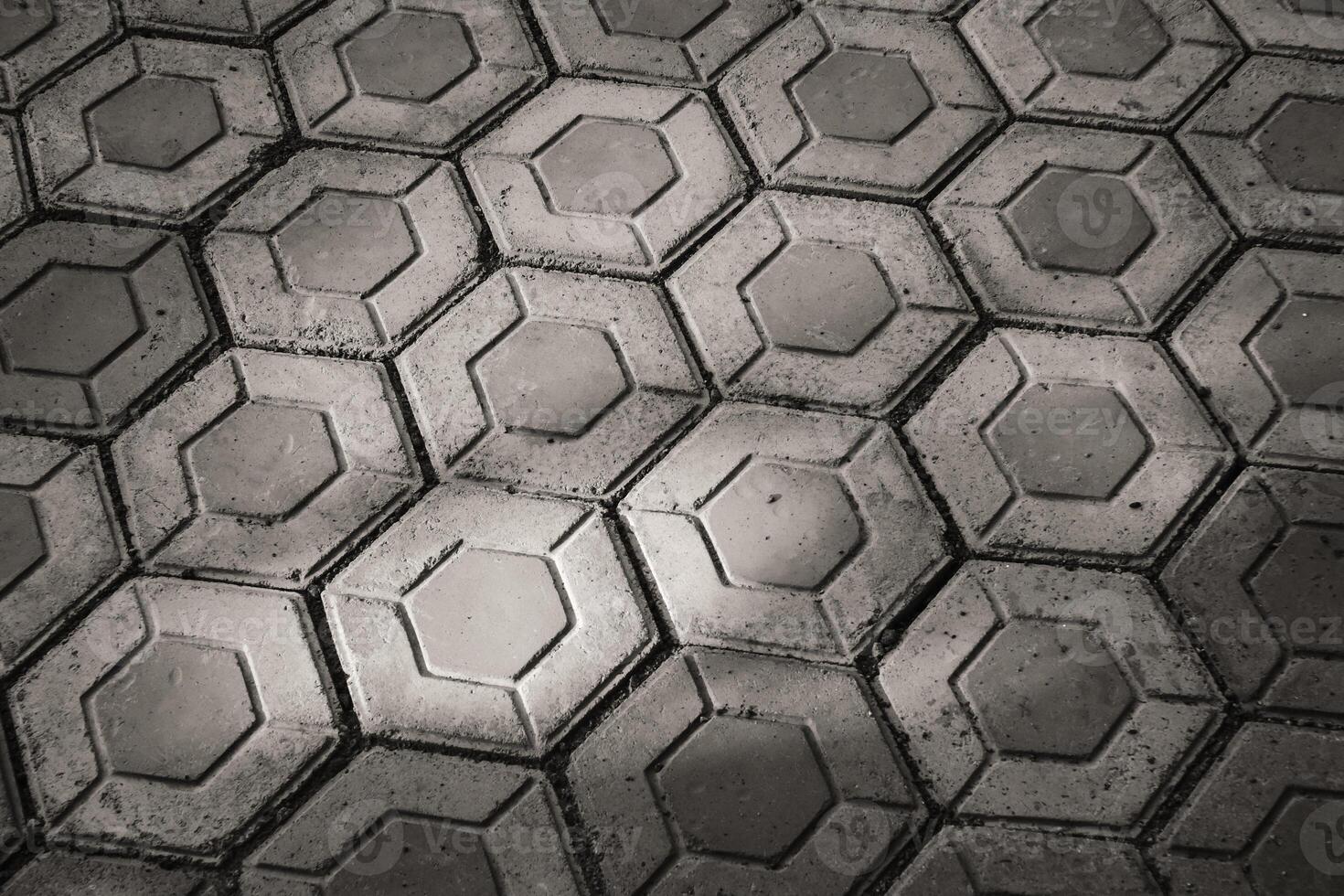 Hexagonal paving block exposed to morning sunlight. Black and white paving block neatly arranged. Hexagon pattern pavement outdoor texture. Wallpaper Backgrounds photo