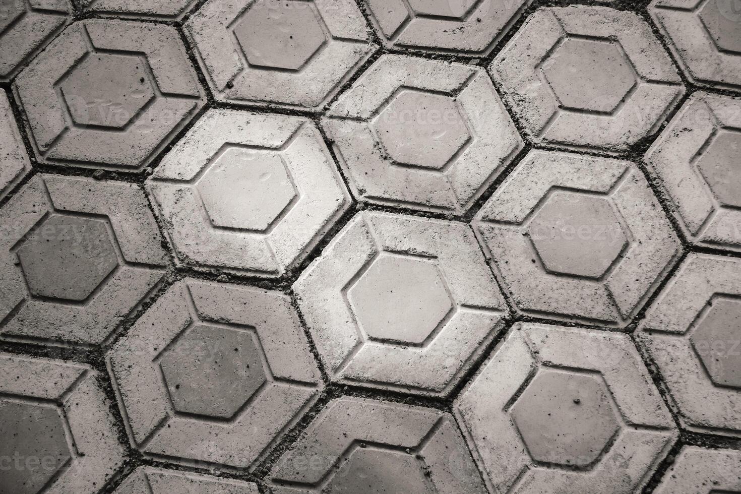 Monochrome hexagonal paving block exposed to morning sunlight. Black and white paving block neatly arranged. Hexagon pattern pavement outdoor texture. photo