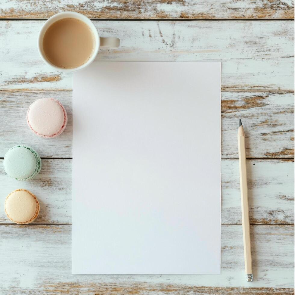 Blank paper, macarons and pencil on white wooden background photo