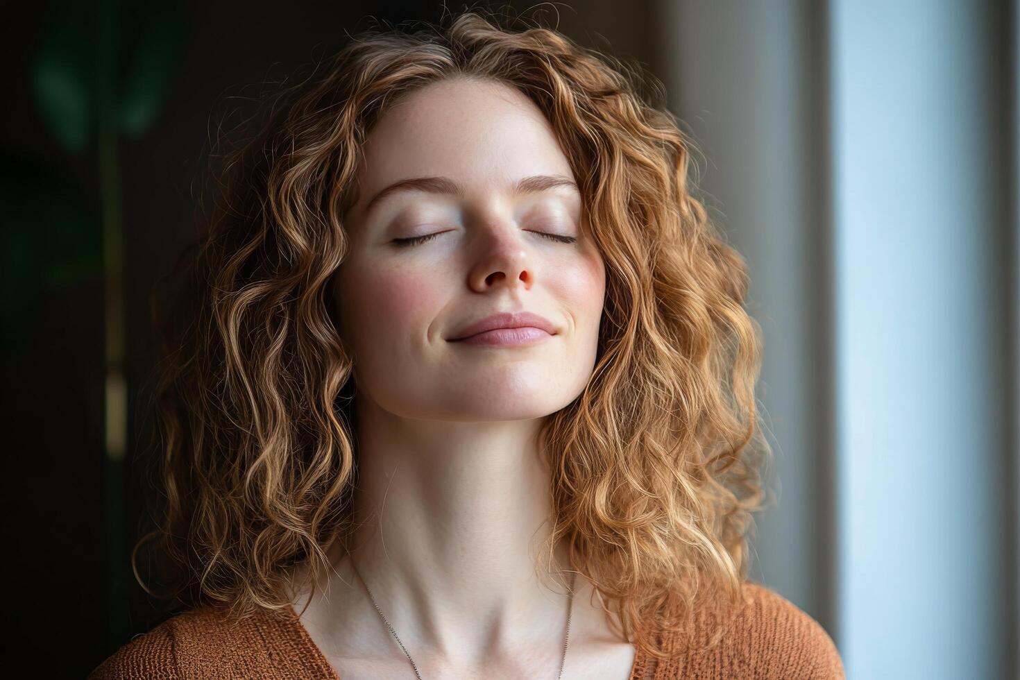 A woman with her eyes closed and her head tilted up photo