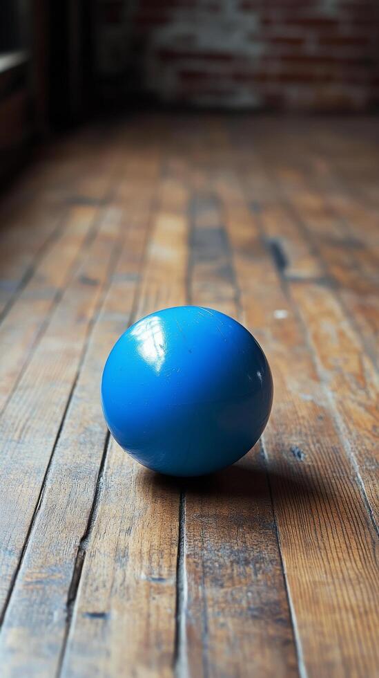 A blue ball sitting on a wooden floor photo