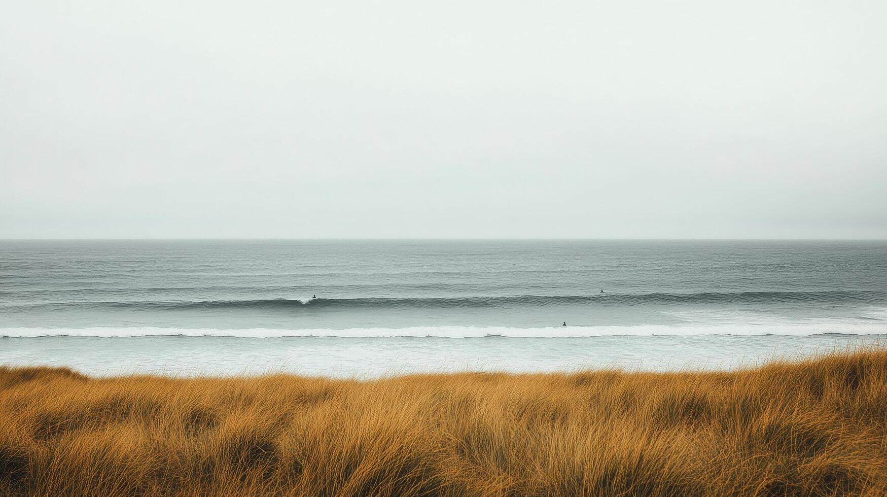 A lone surfer in the ocean on a cloudy day photo