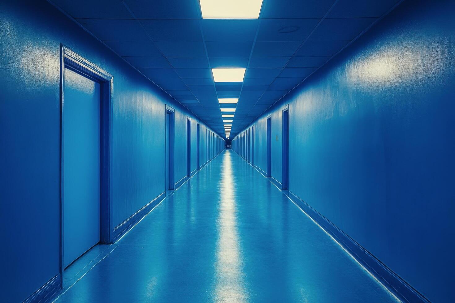 A long hallway with blue walls and doors photo