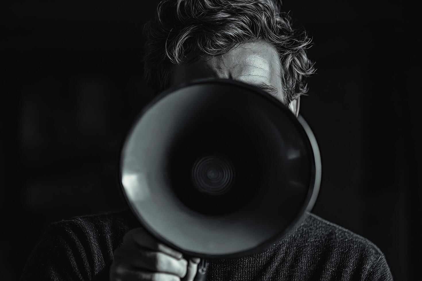 A man holding a megaphone in front of his face photo