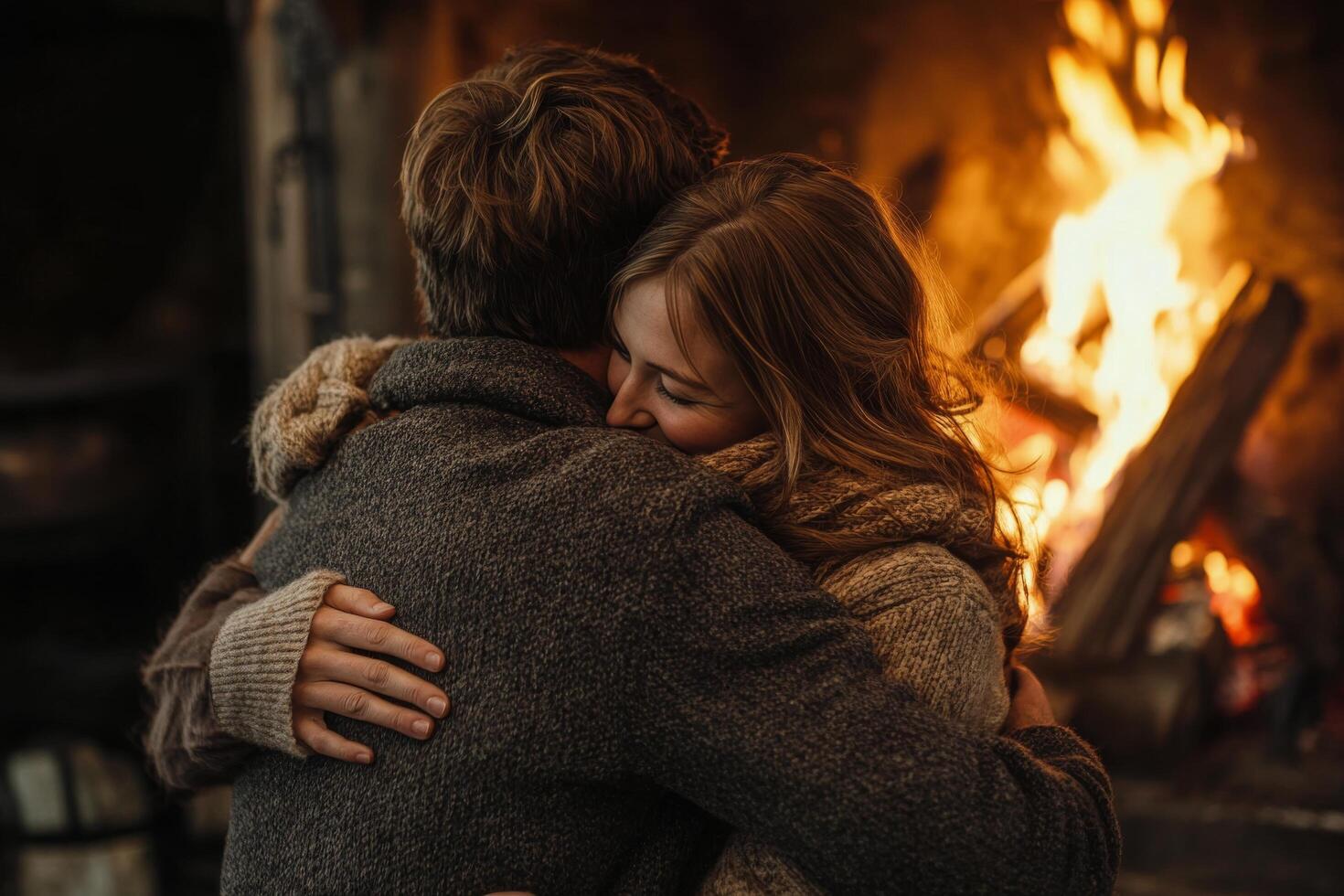 A couple hugging in front of a fireplace photo