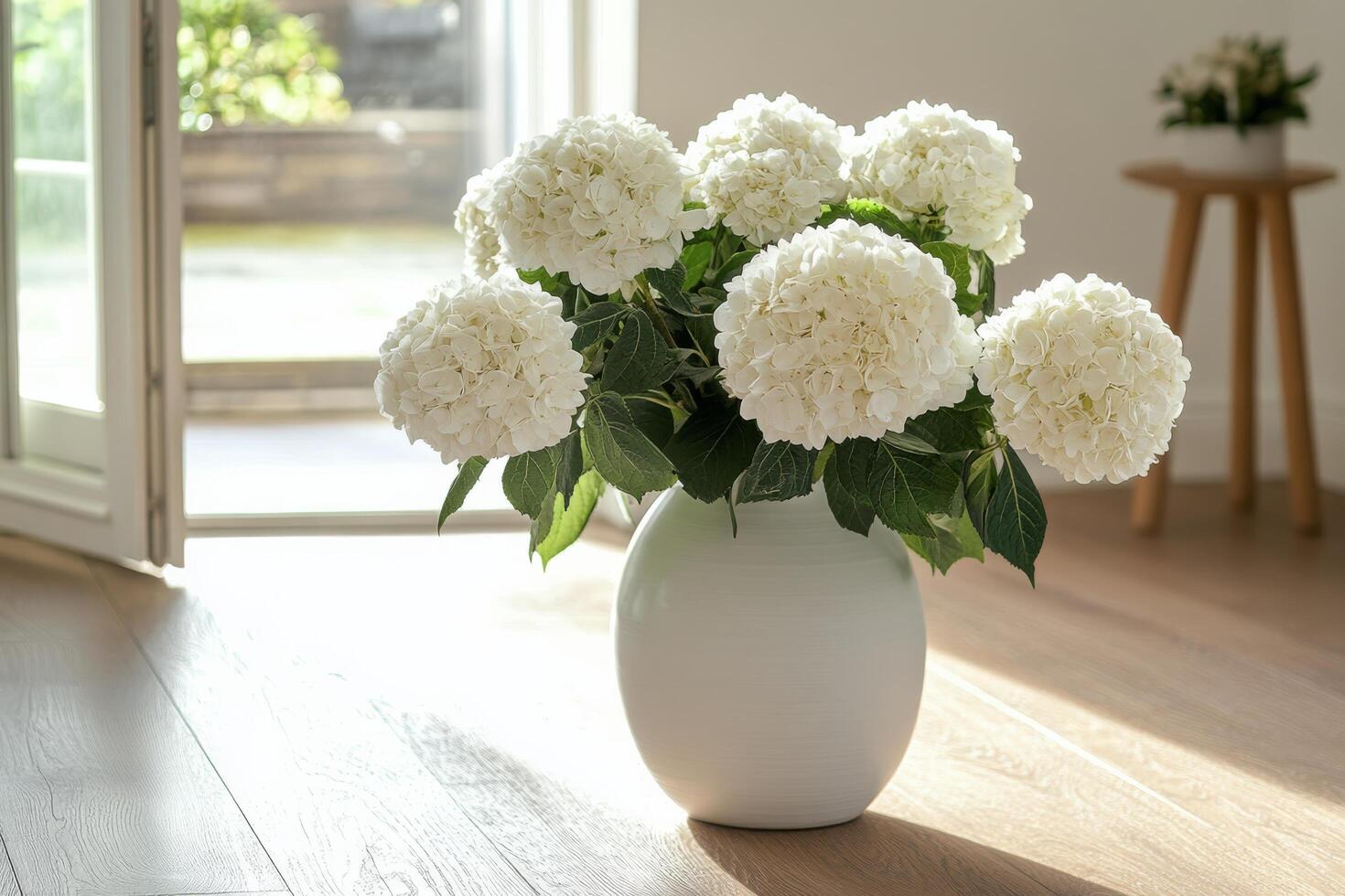 A vase of white flowers sitting on a wooden floor photo