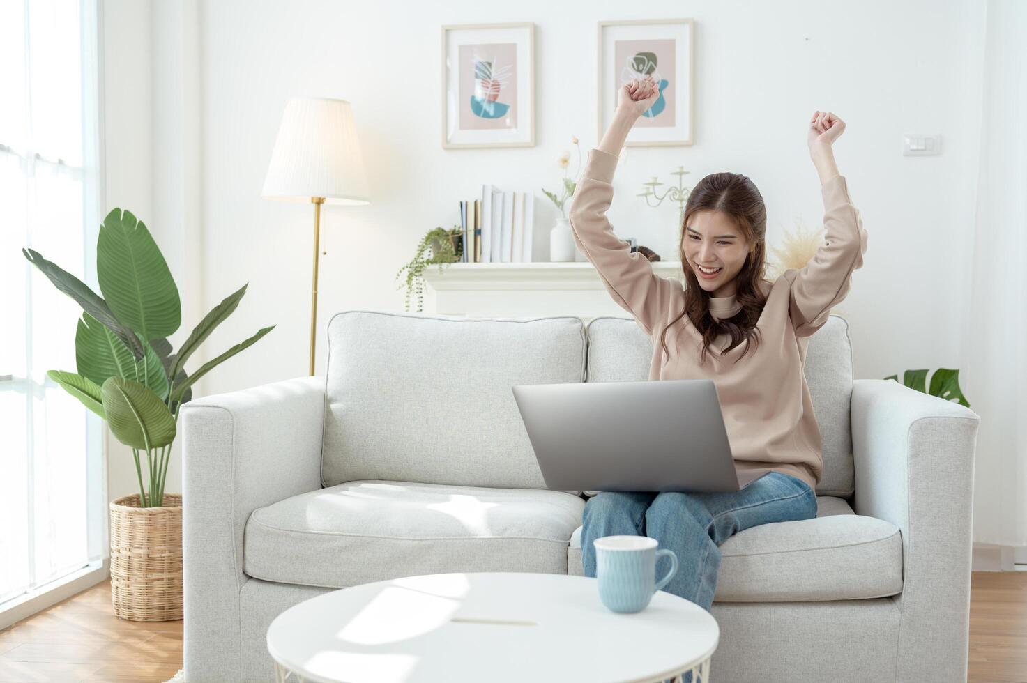 Woman Enjoys Working on a Laptop While Sipping Coffee in a Cozy Living Room Setting photo