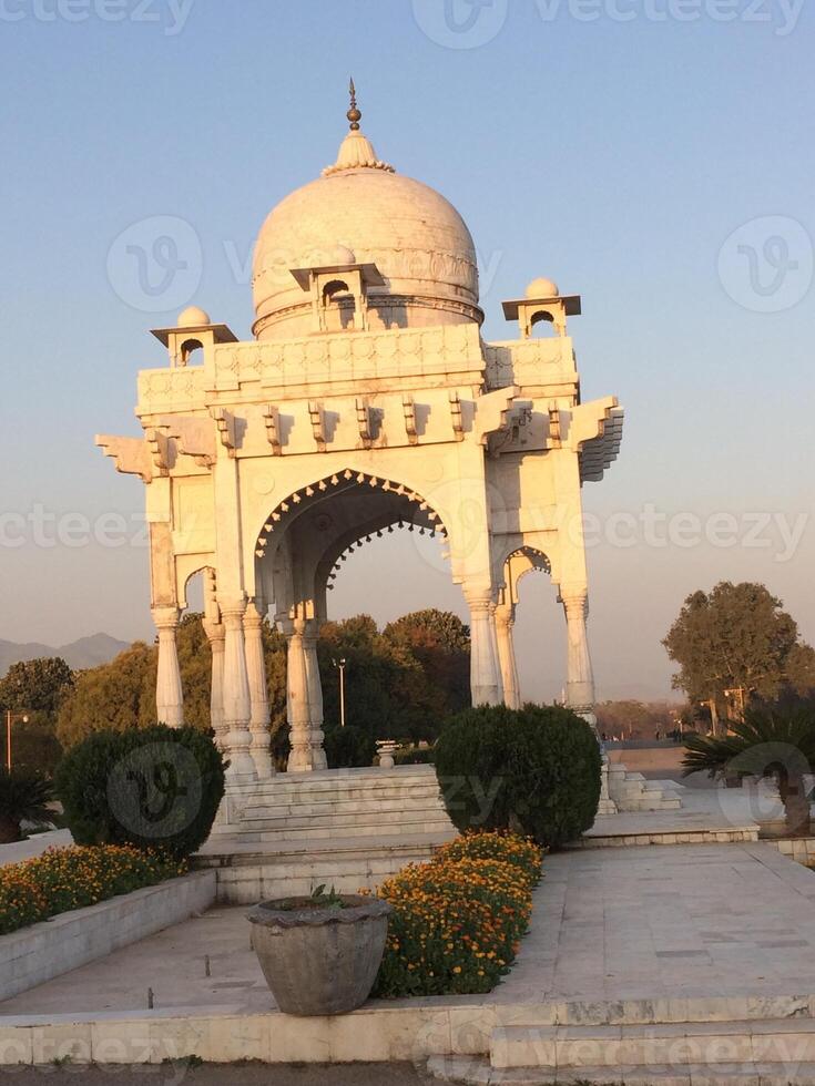 A white marble structure with a dome on top photo