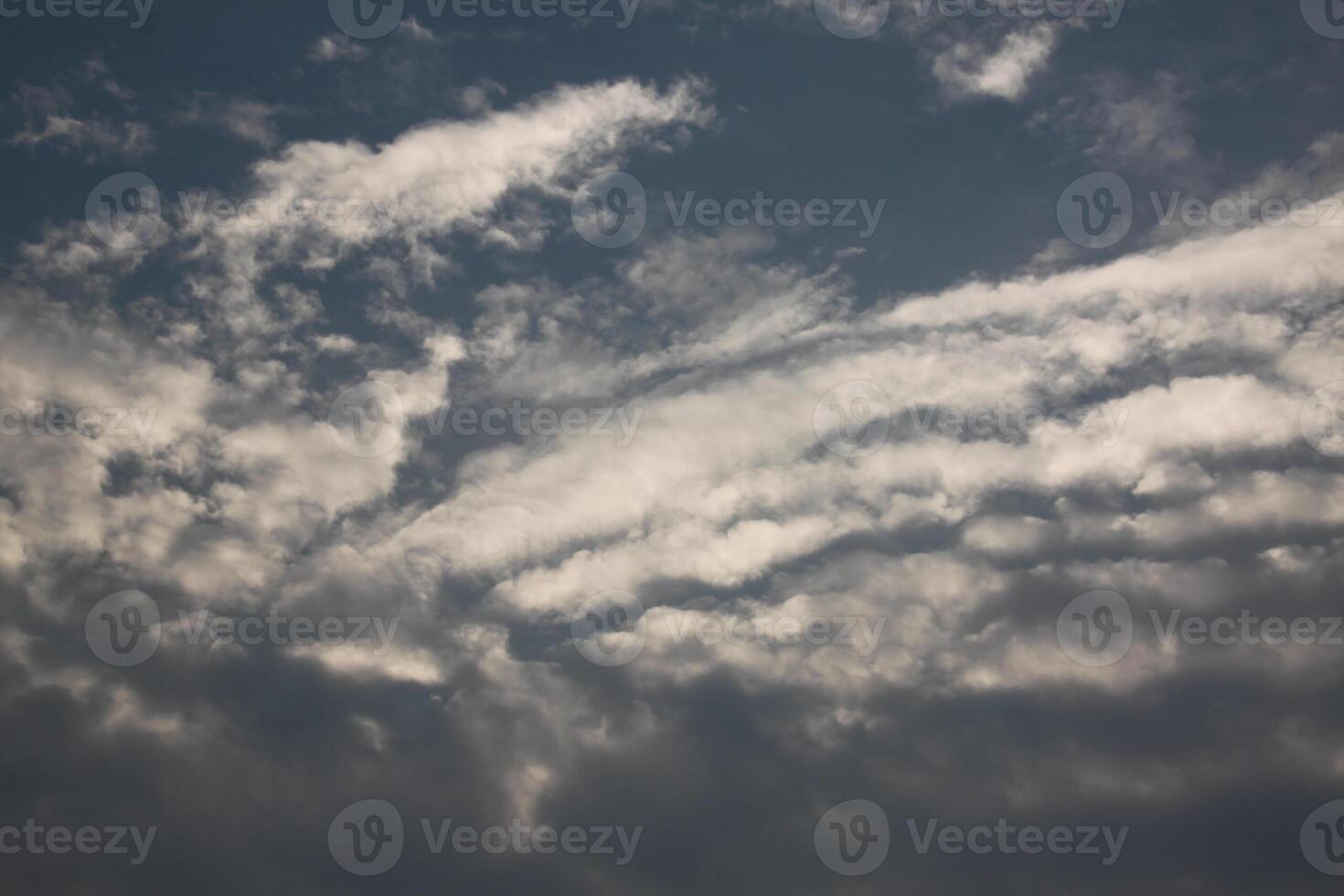 A plane flying in the sky with some clouds photo
