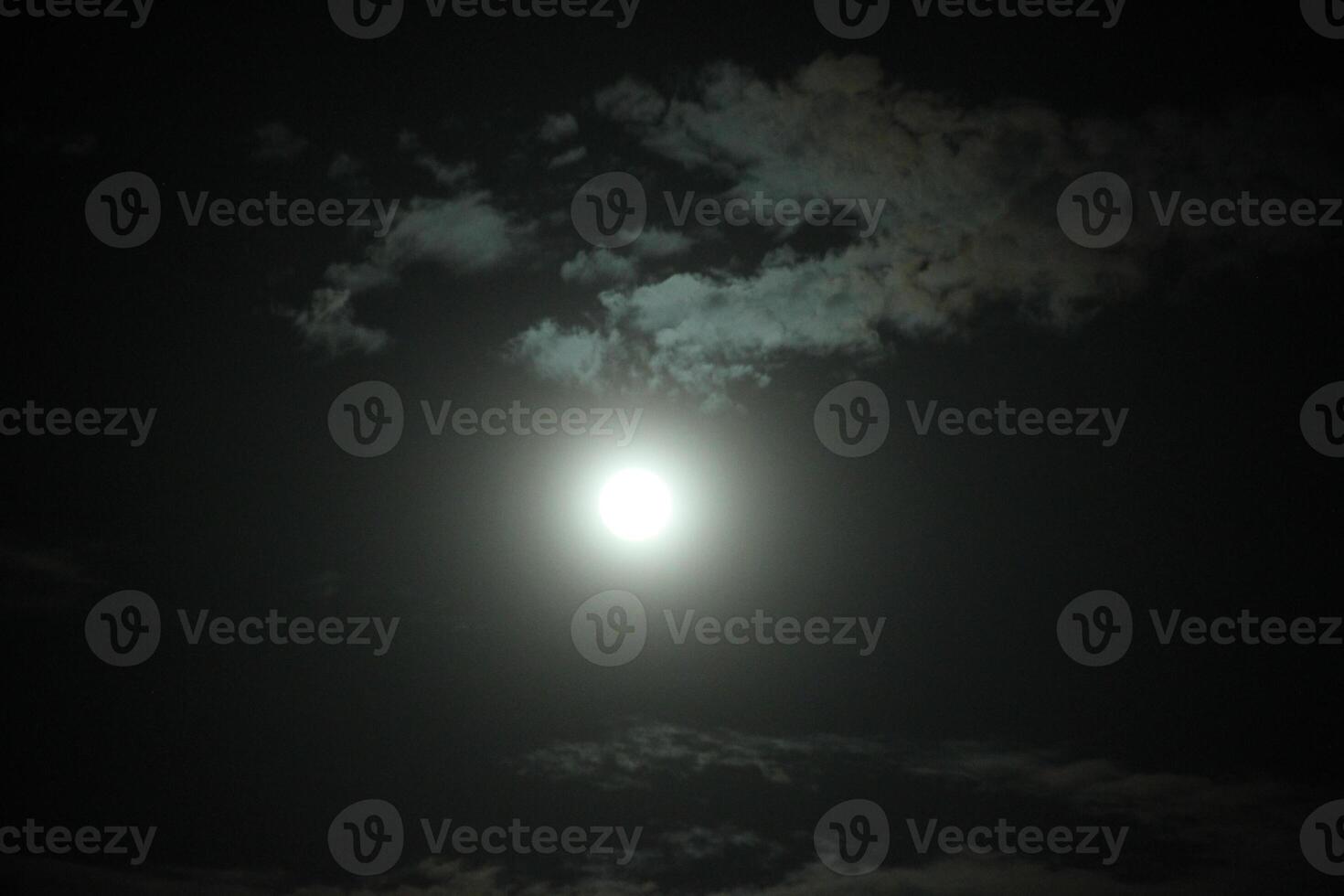 The moon is shining brightly in the dark sky photo