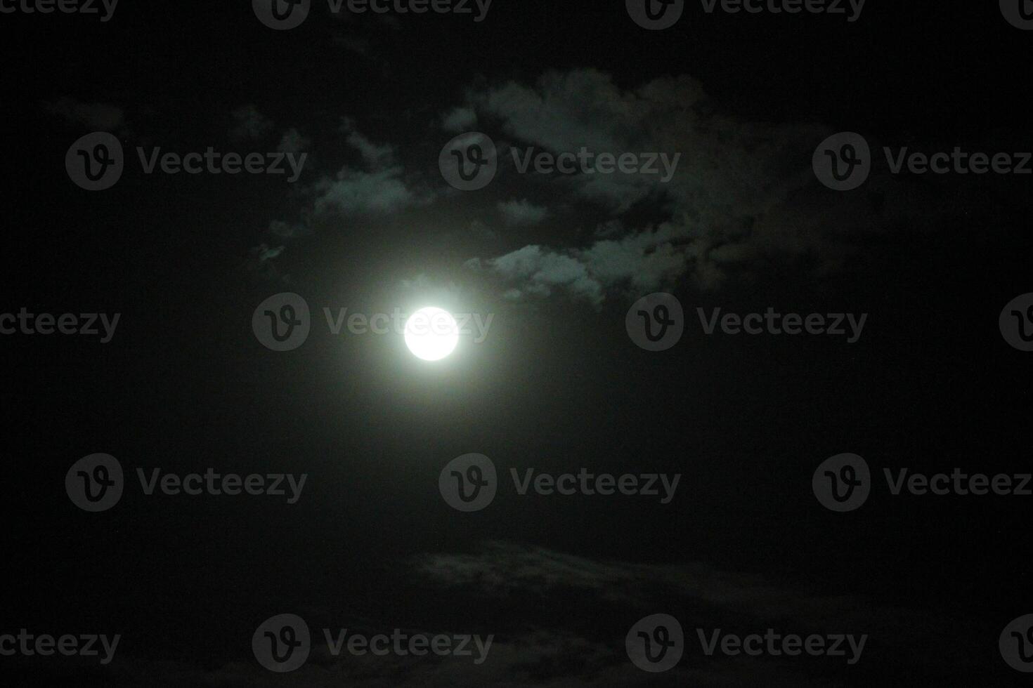 The moon is shining brightly in the dark sky photo